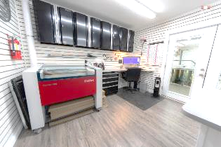 A room with a desk , chair , and a machine.