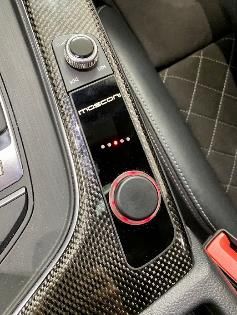 A close up of a control panel in a car with a red button.