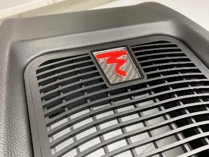 A close up of a speaker grille with a red r on it.