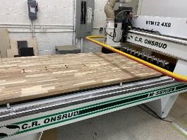 A machine is cutting a piece of wood on a table.