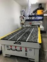 A large machine is sitting in a room next to a wall.