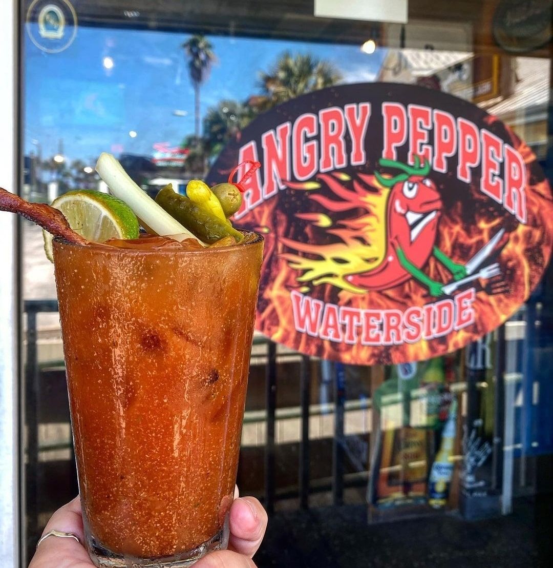 bloody mary cocktail with restaurant sign behind it