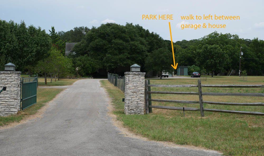A road with an arrow pointing to the garage and house