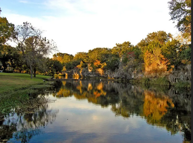 A river with trees on the shore and trees reflected in the water
