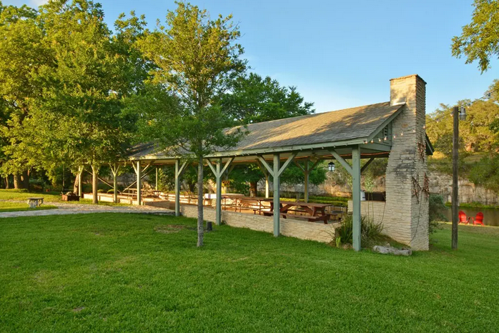 There is a picnic shelter in the middle of a park.