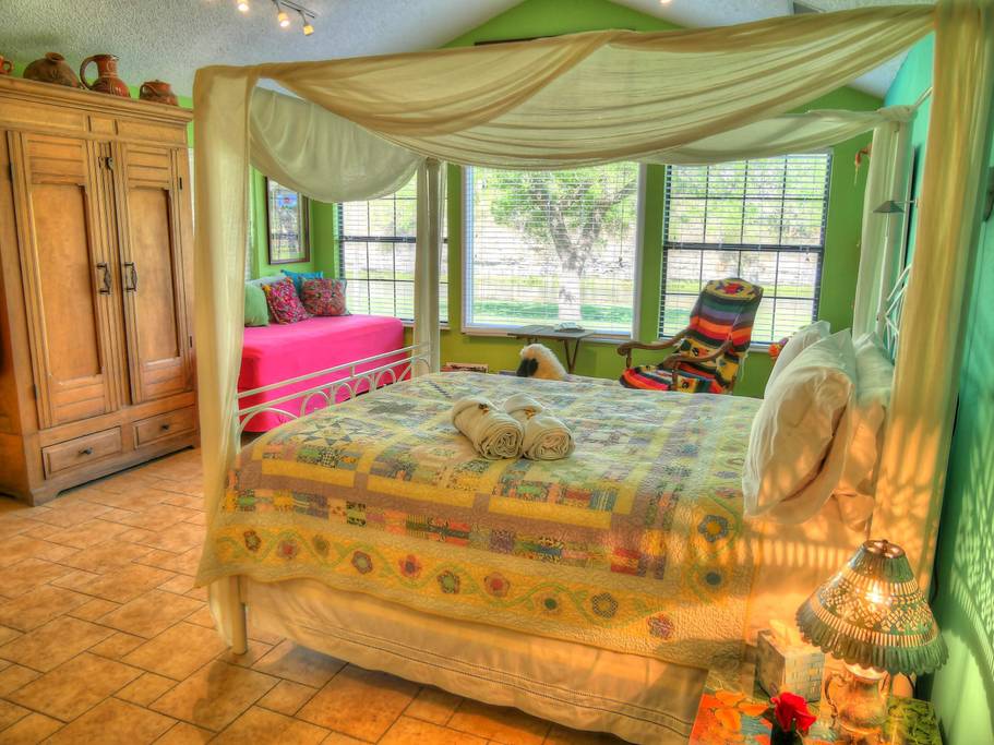 A bedroom with a canopy bed and a pink couch