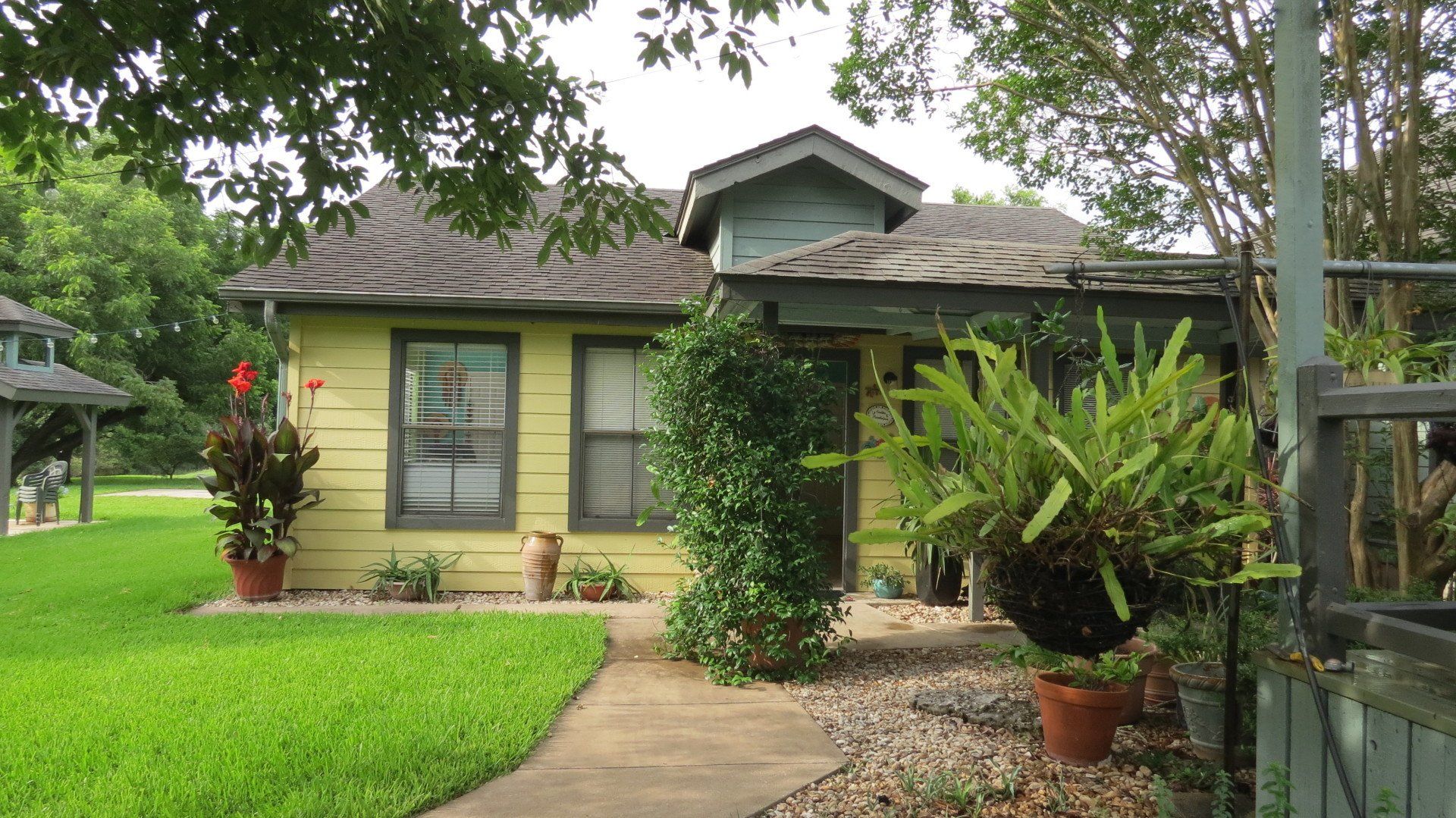 A small yellow house with a walkway leading to it