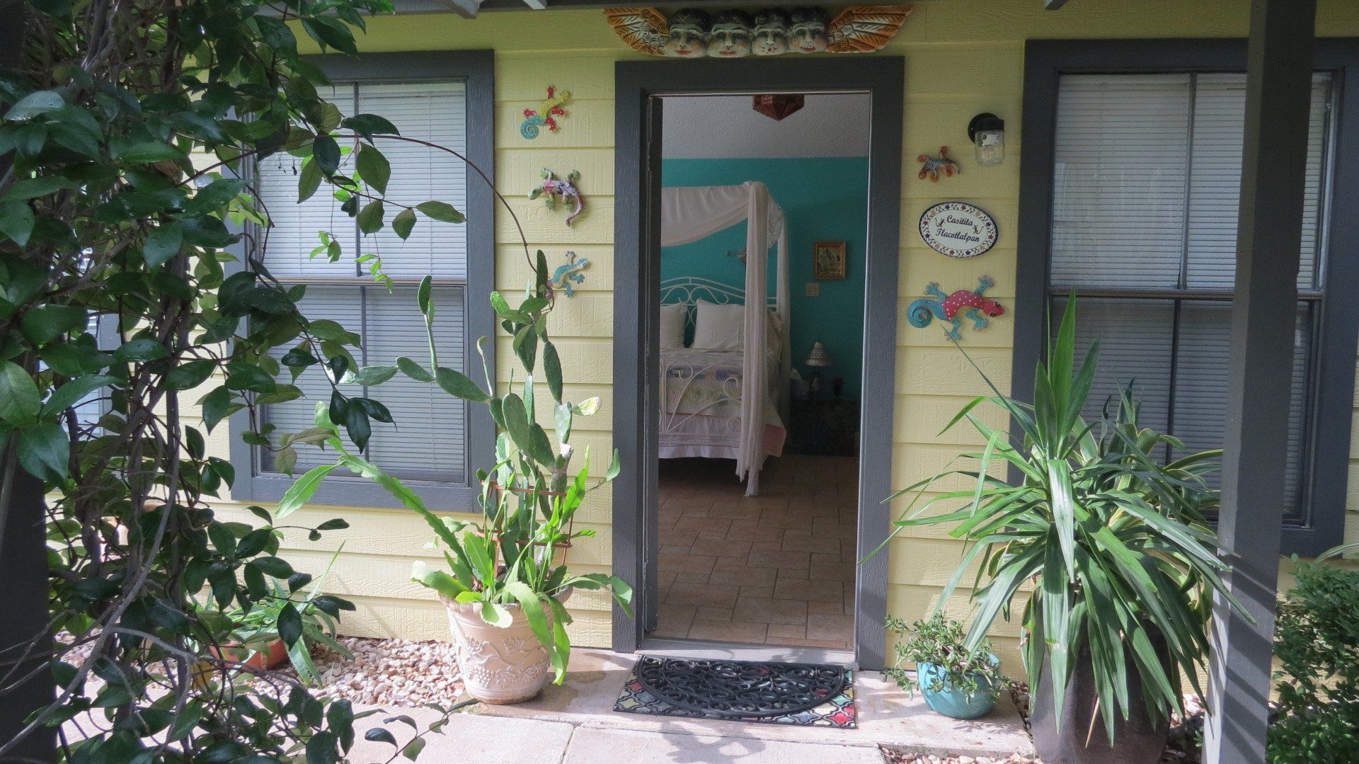 A yellow house with a clock on the side of it