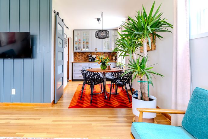 Real estate living room with a dining room table and chairs and a potted plant.