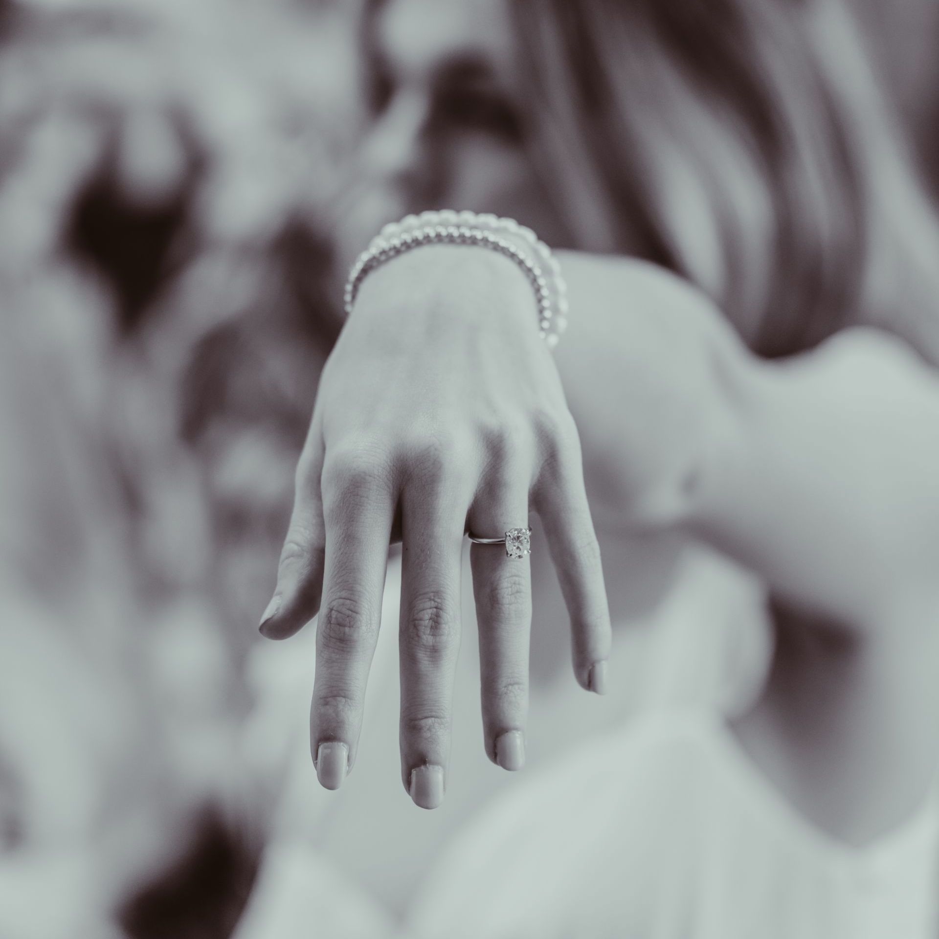 An engaged woman's hand with a wedding ring on it