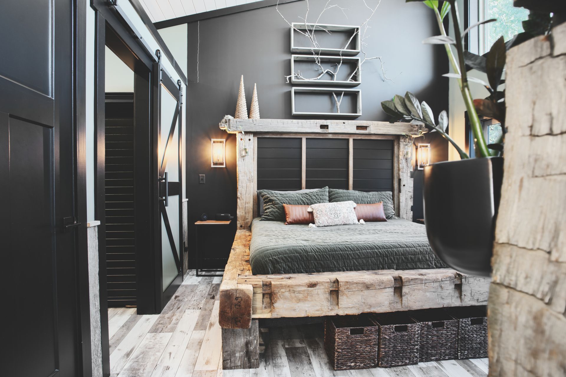 A bedroom with a wooden bed and a black wall.