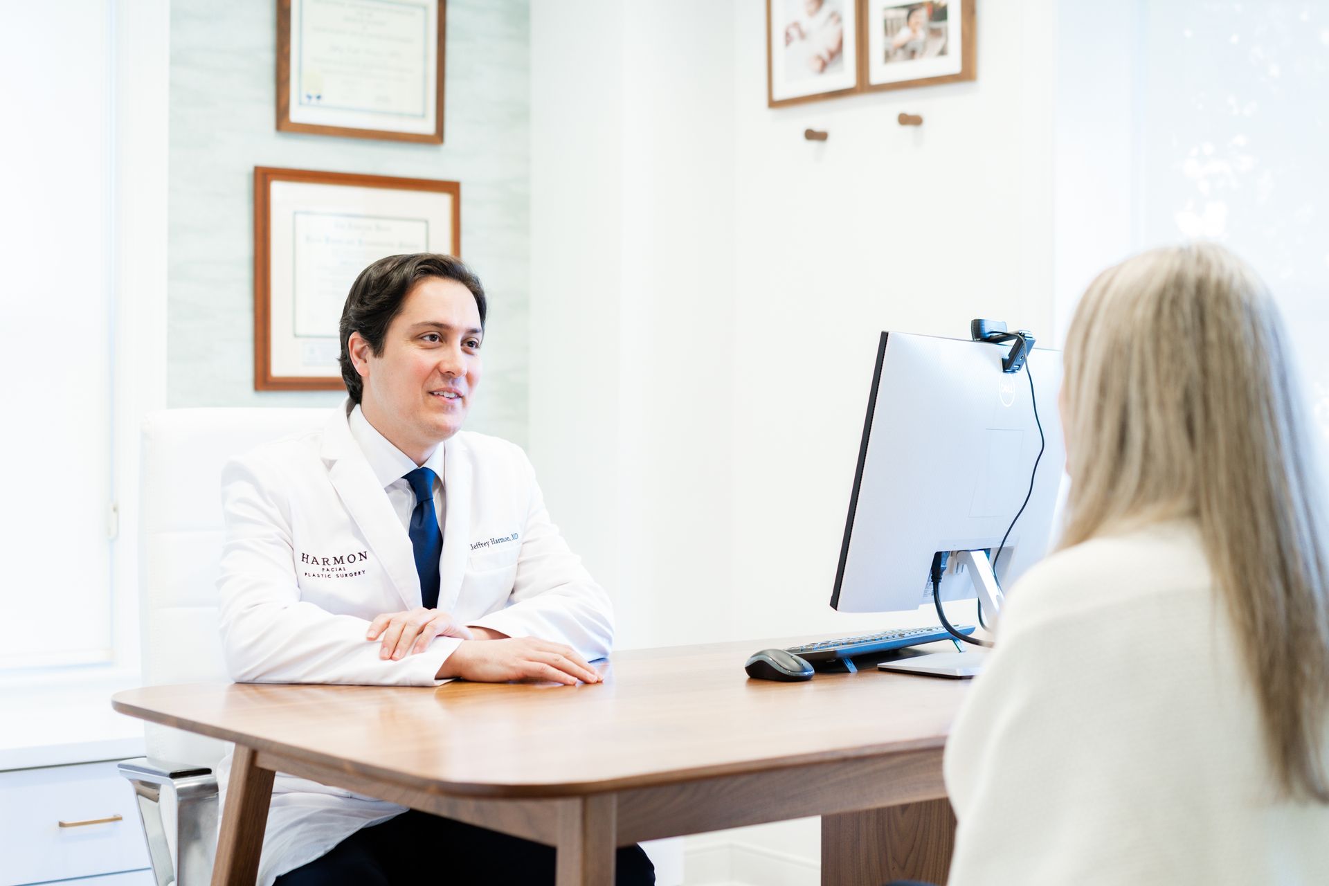 A doctor is sitting at a desk talking to a patient.