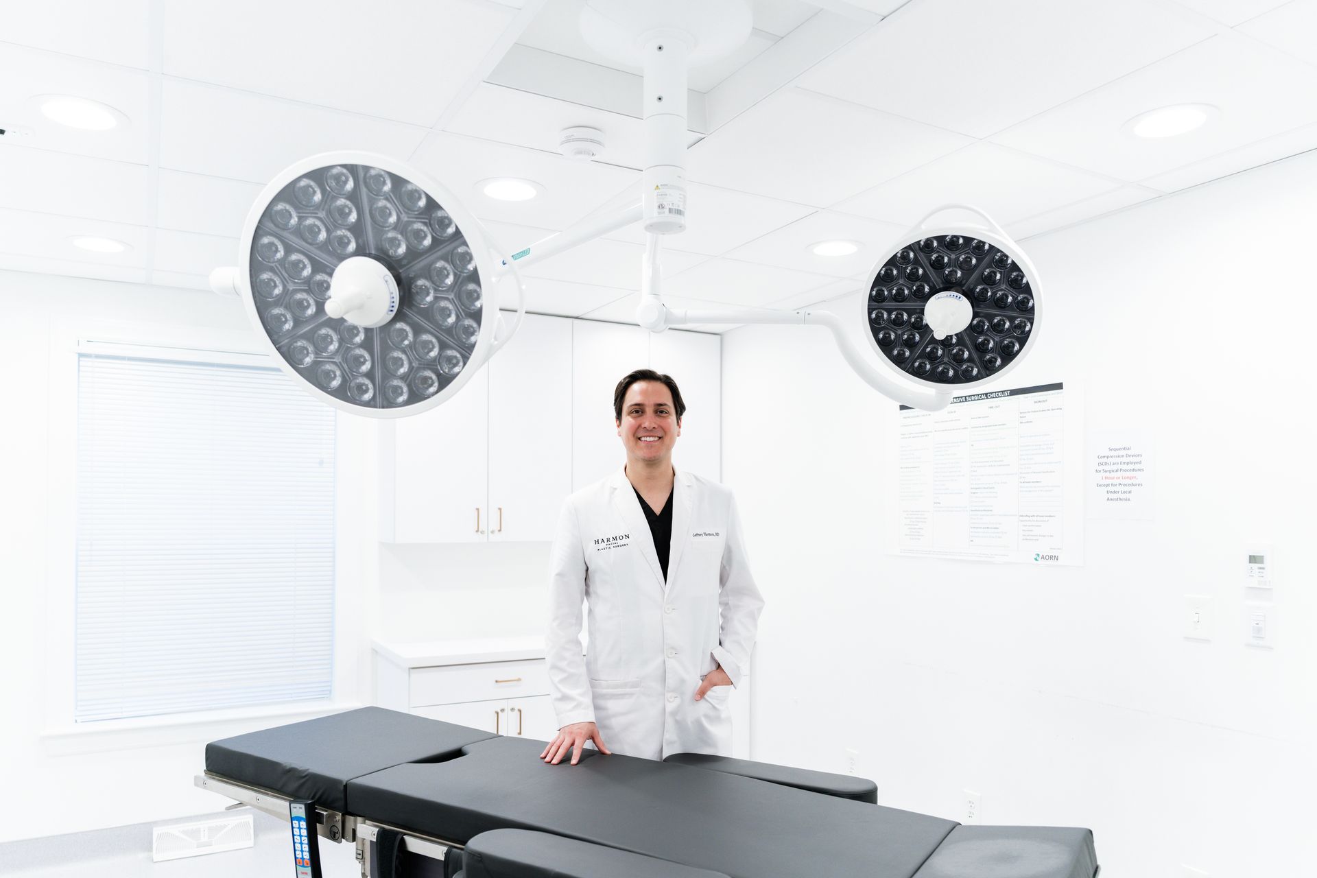 A doctor is standing in front of an operating table in an operating room.