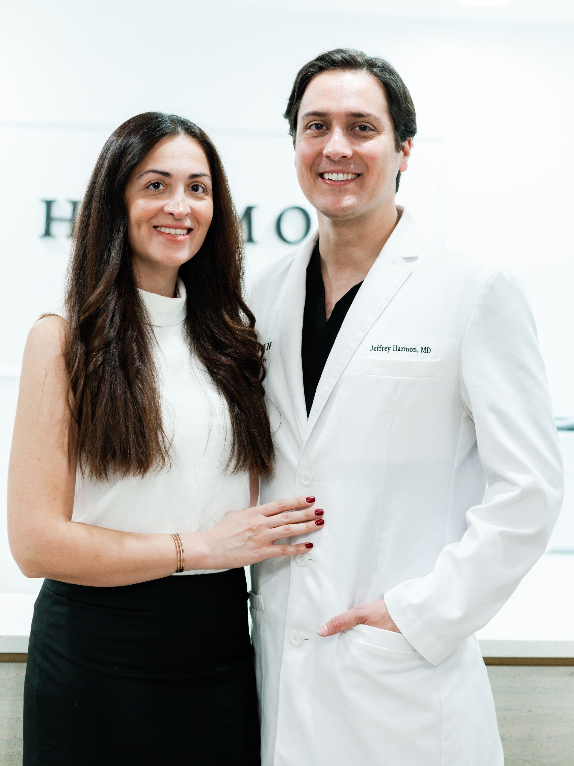 A man and a woman in white coats are posing for a picture.