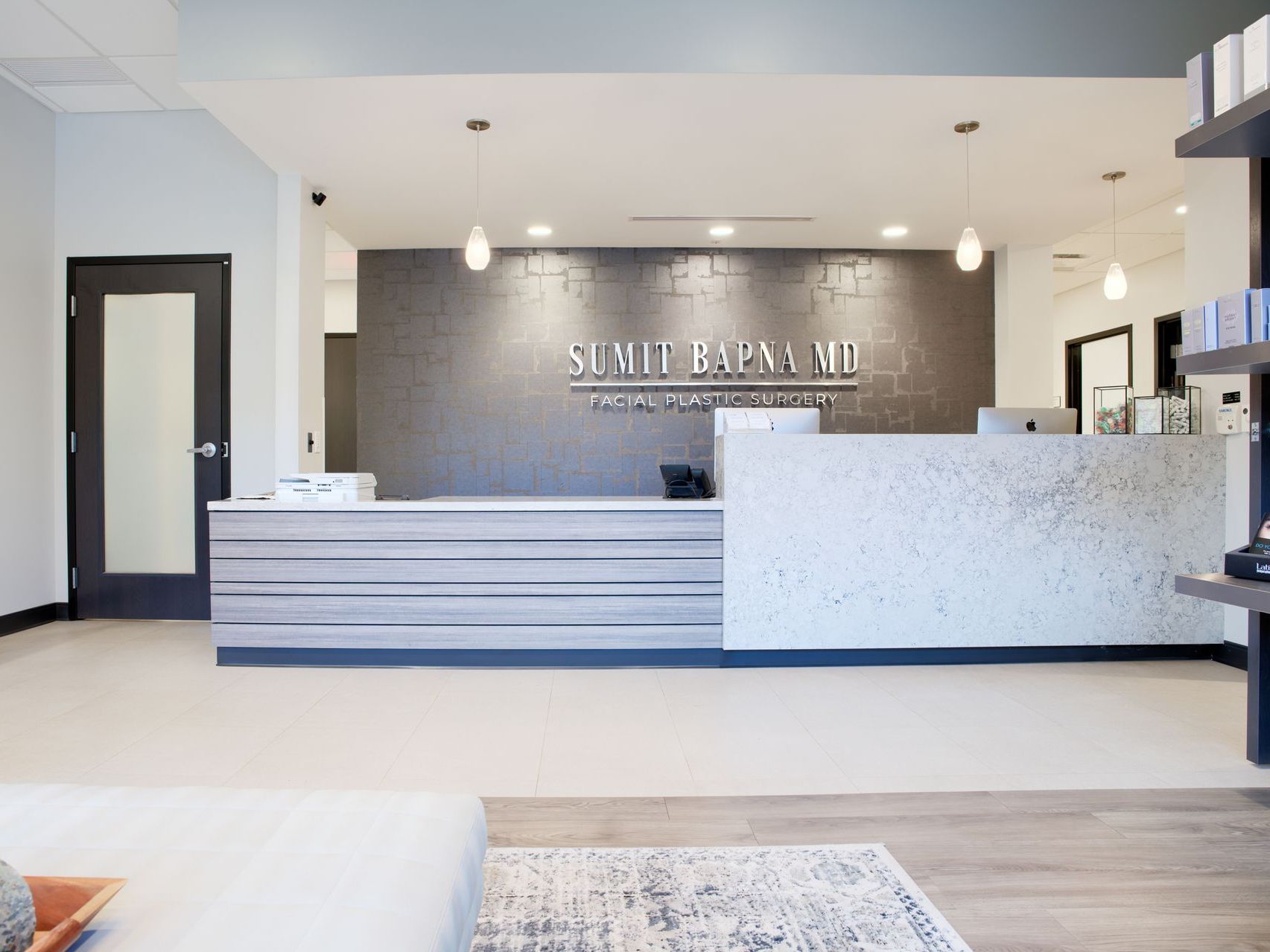 A dental office with a reception desk and a couch in the background.