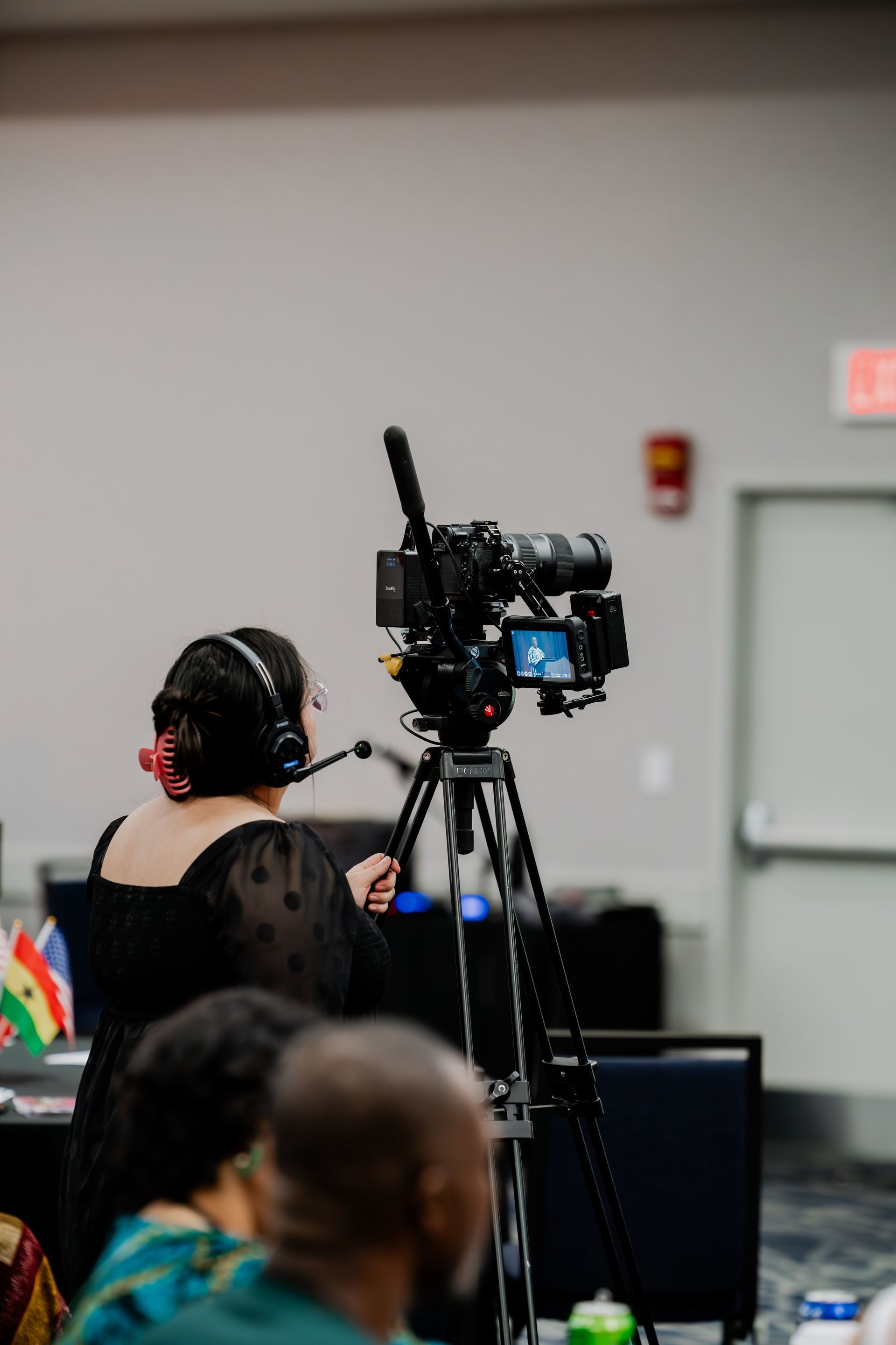 A woman is sitting in front of a camera in a room.