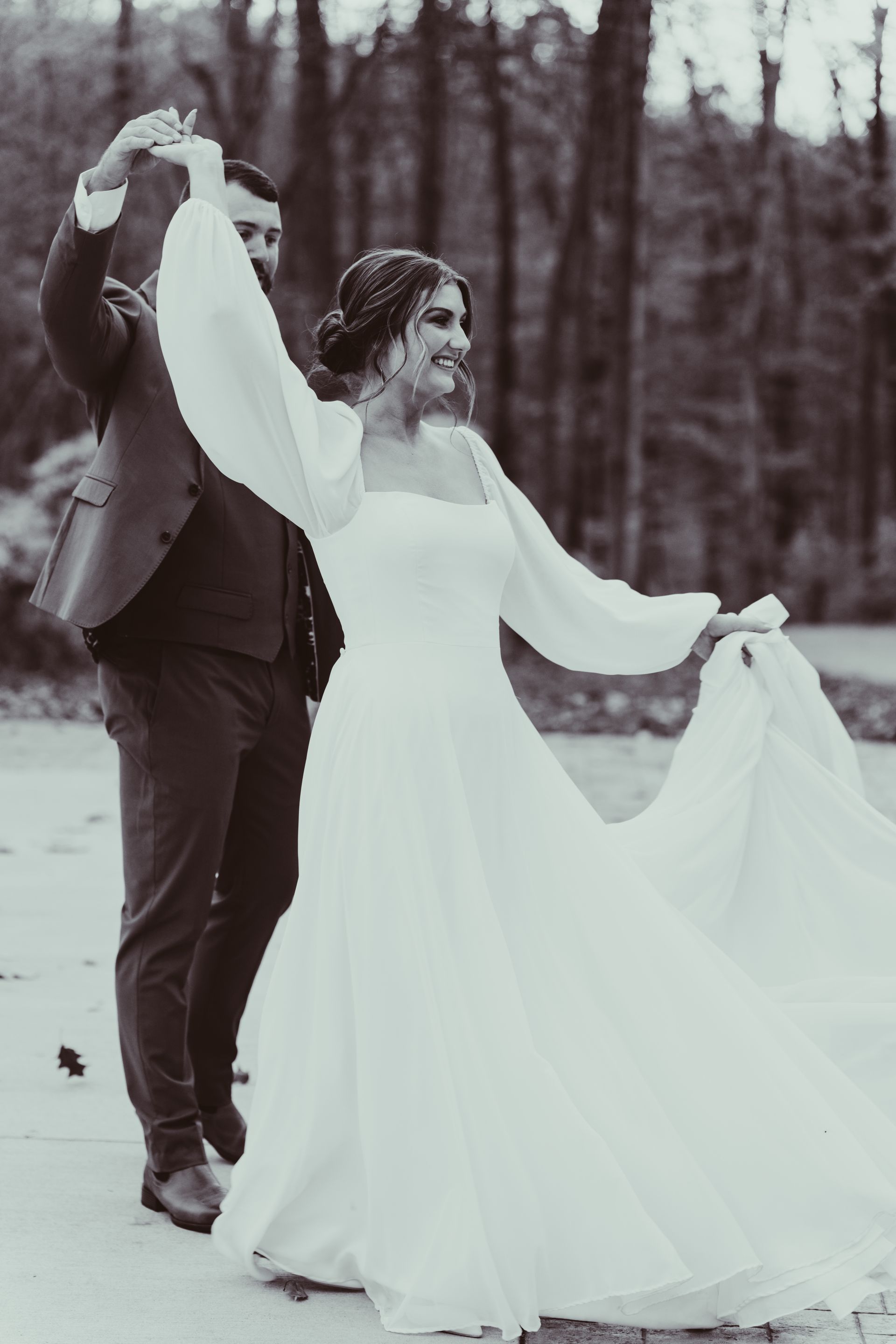 a black and white photo of a bride and groom dancing .