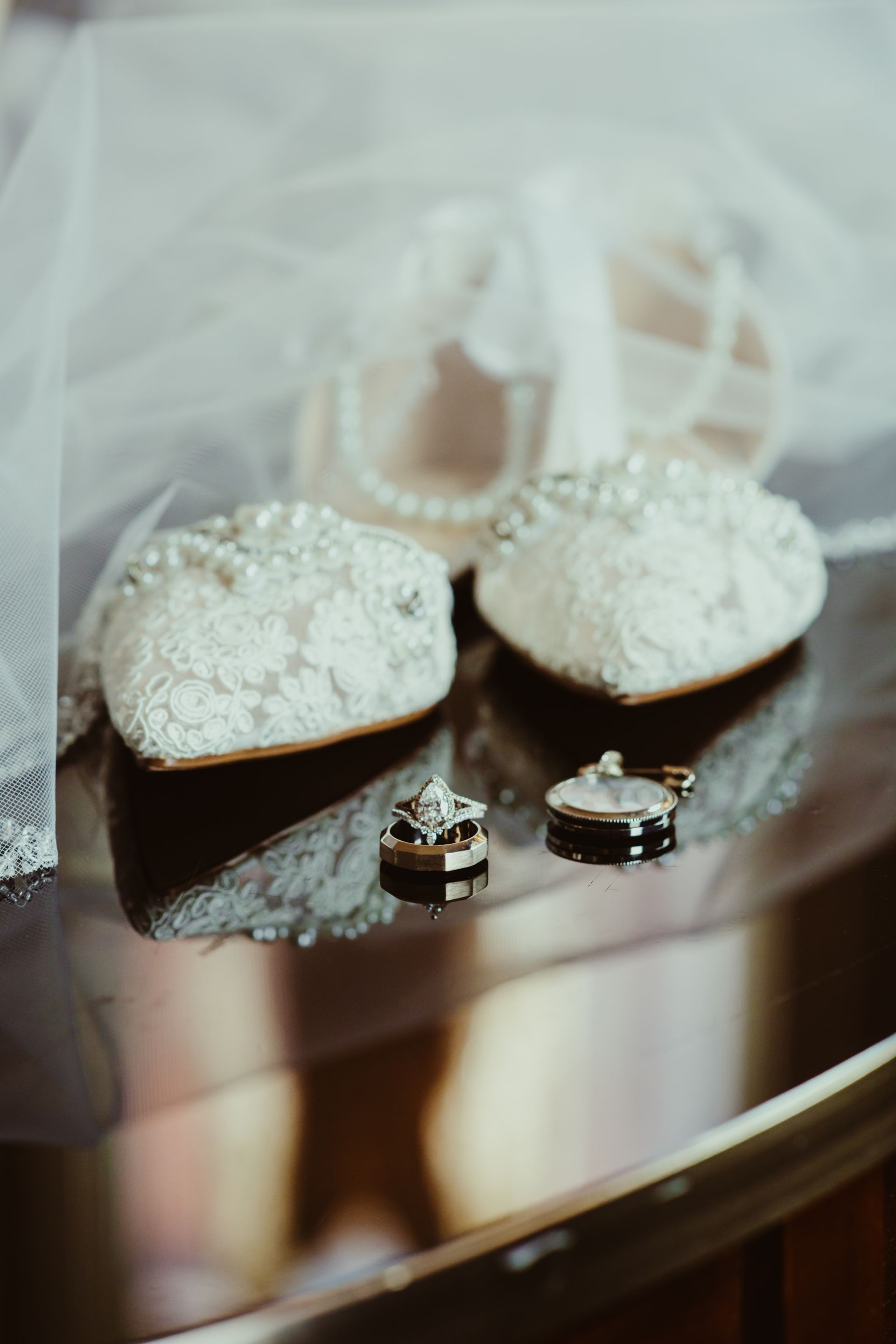 a pair of wedding shoes and wedding rings are sitting on a table .