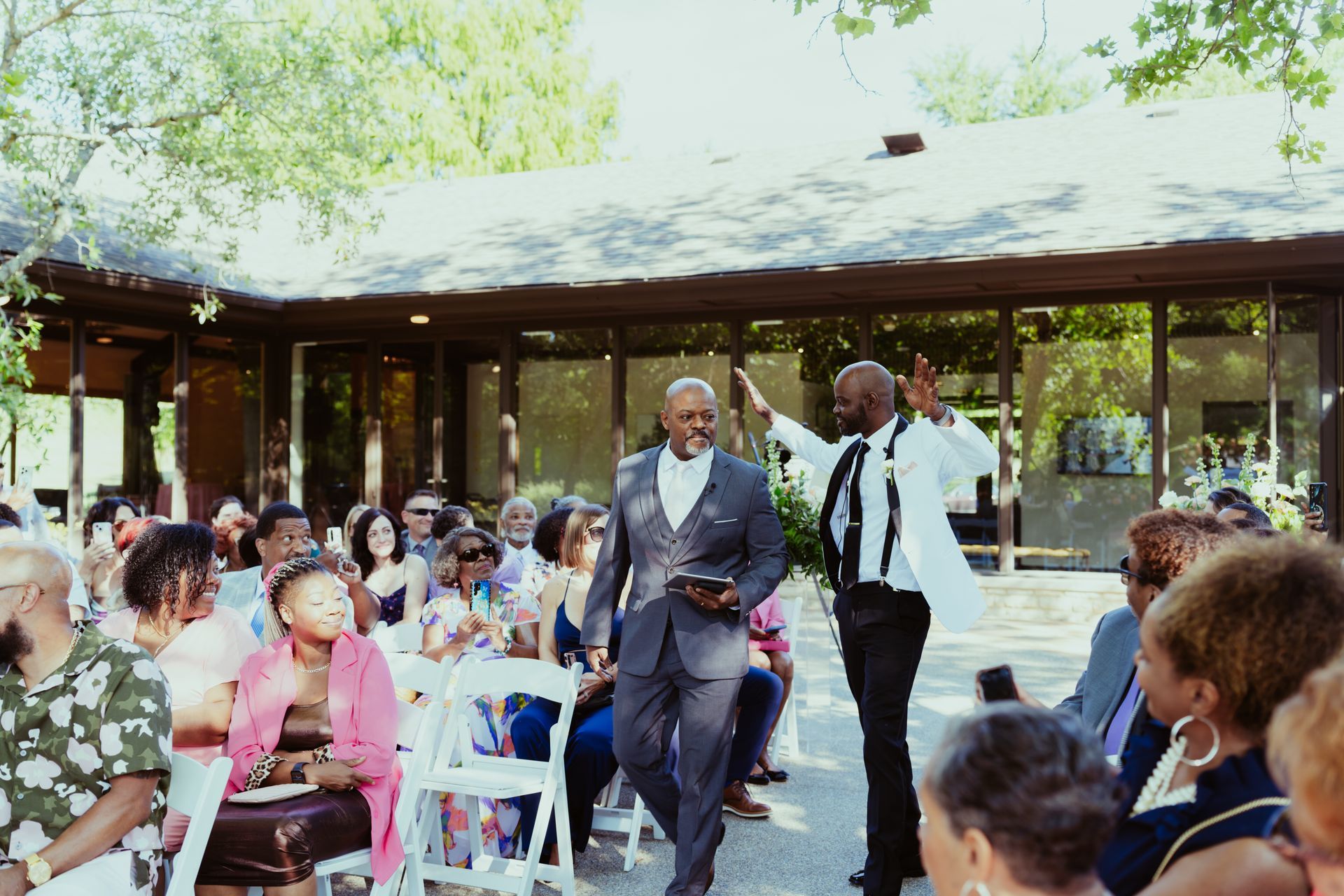 A man in a suit is walking down the aisle at a wedding.