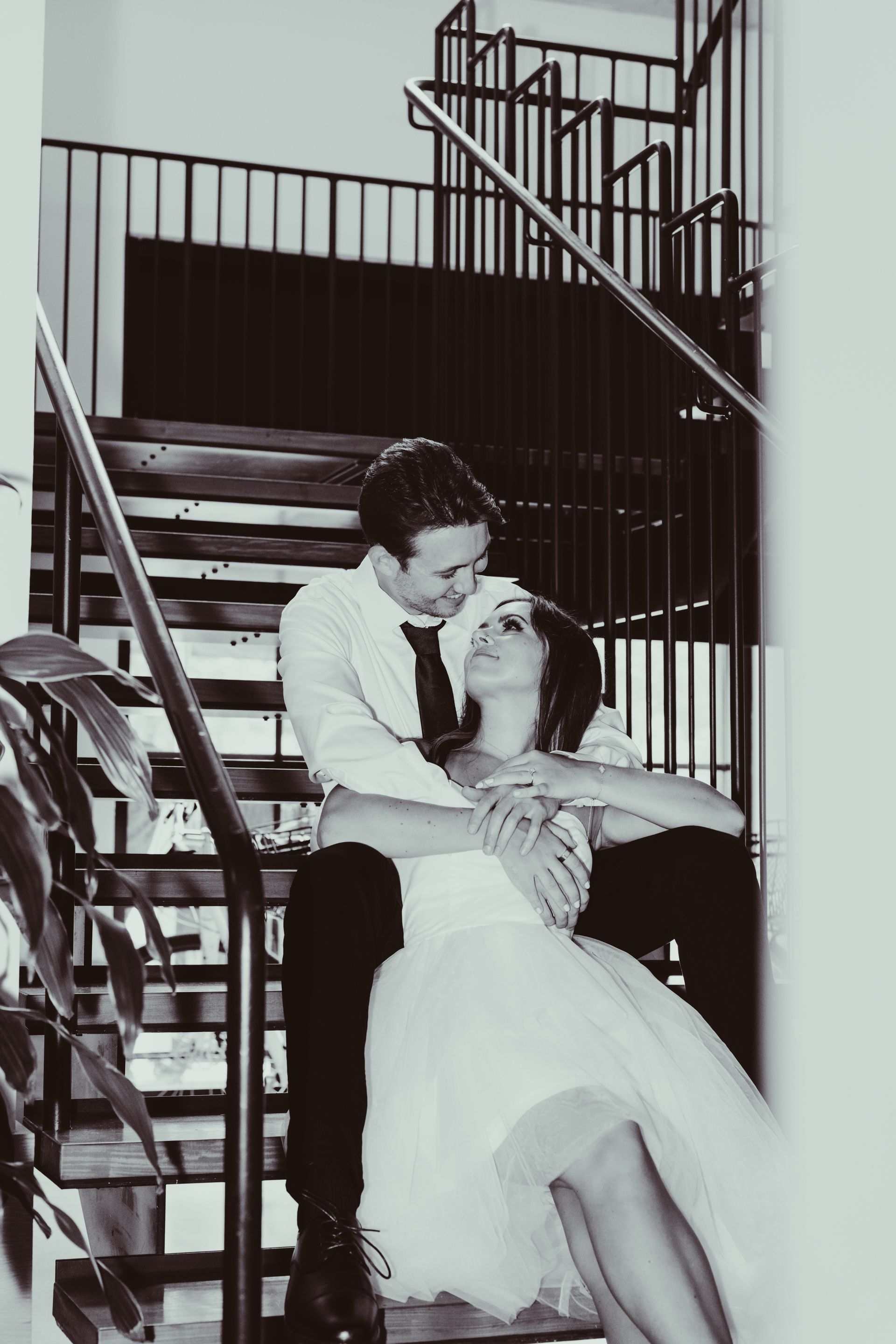 A black and white photo of a bride and groom on stairs