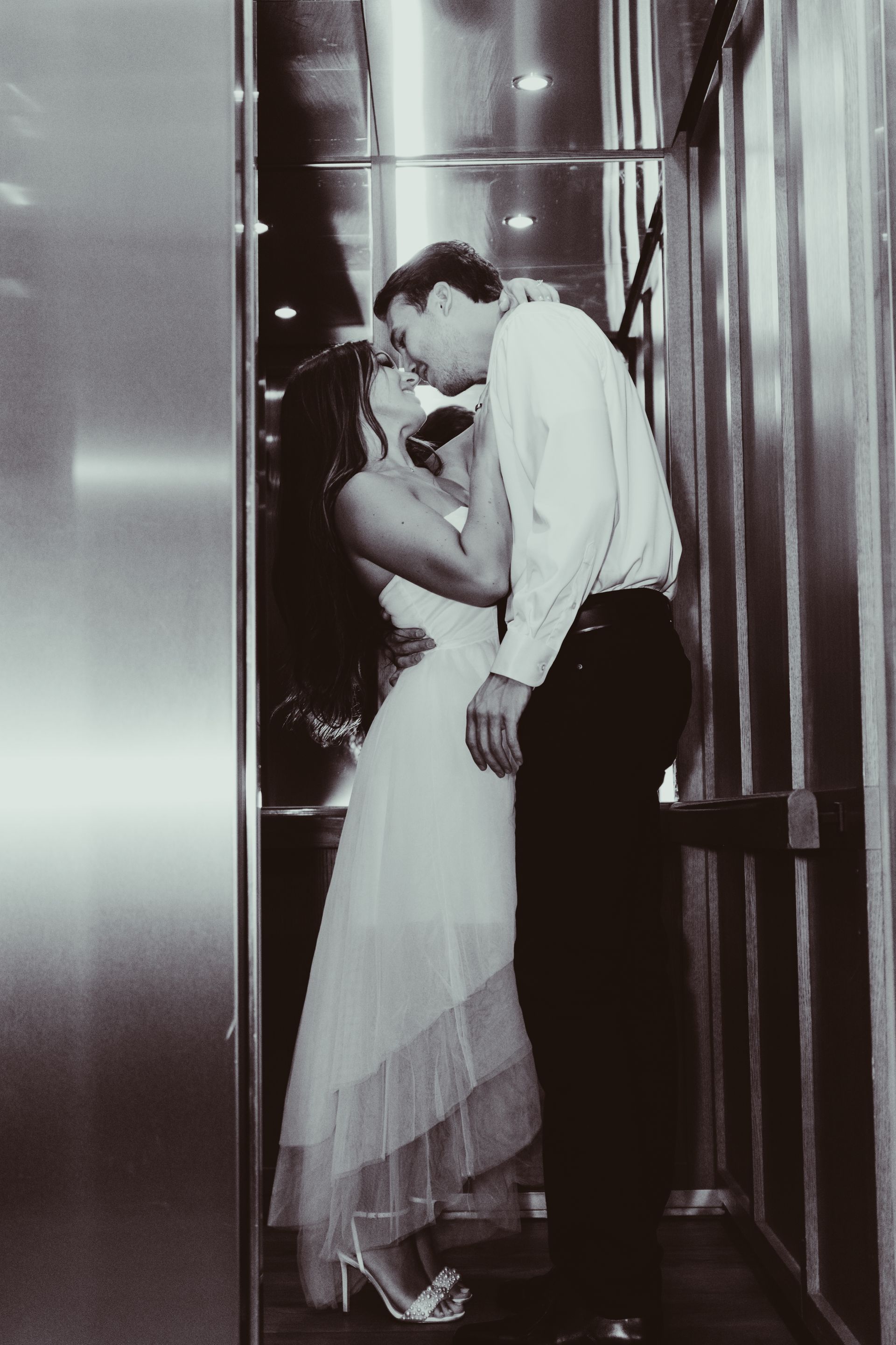 A man and a woman kissing in an elevator