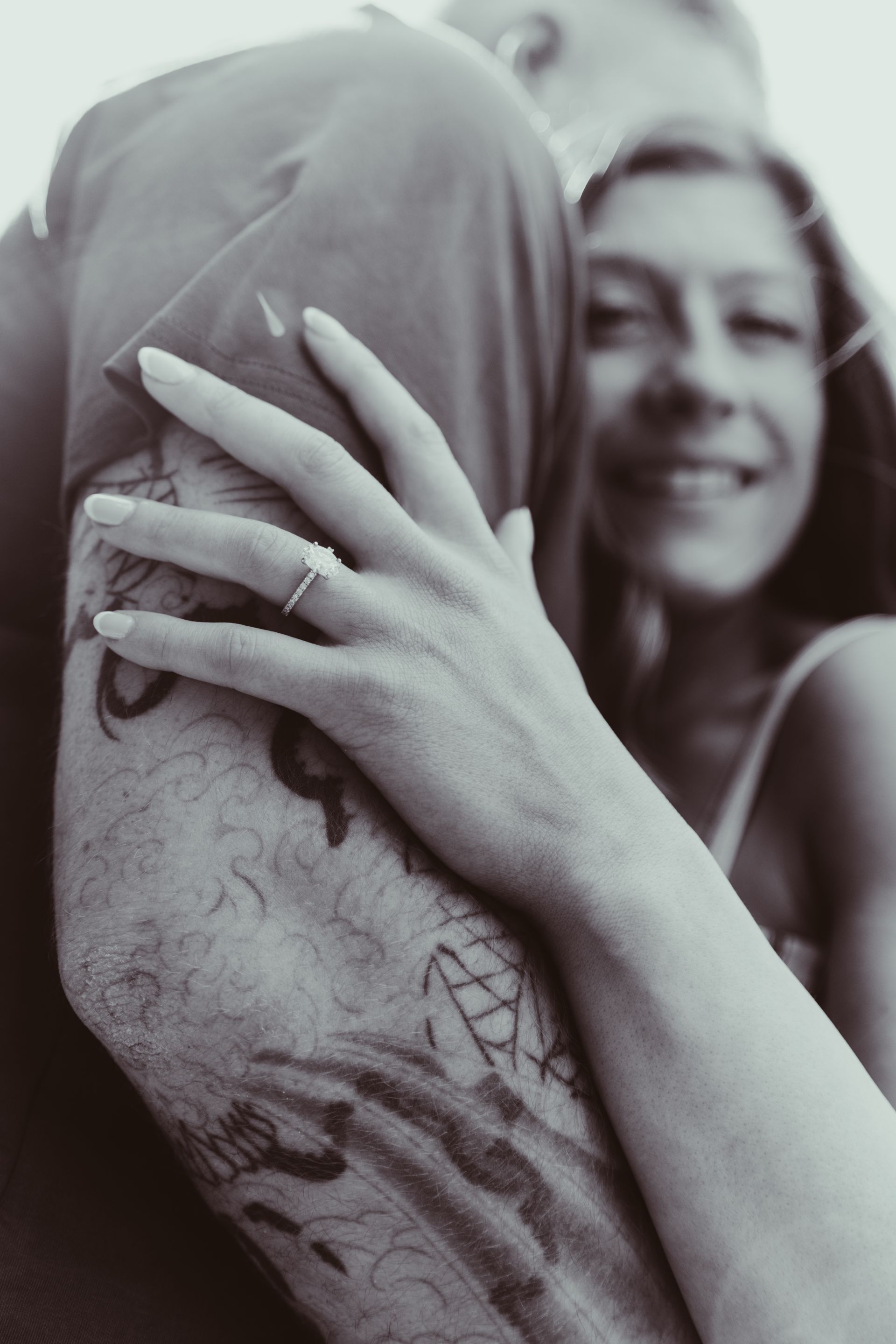 A man is holding a woman in his arms in front of a building that says the unit