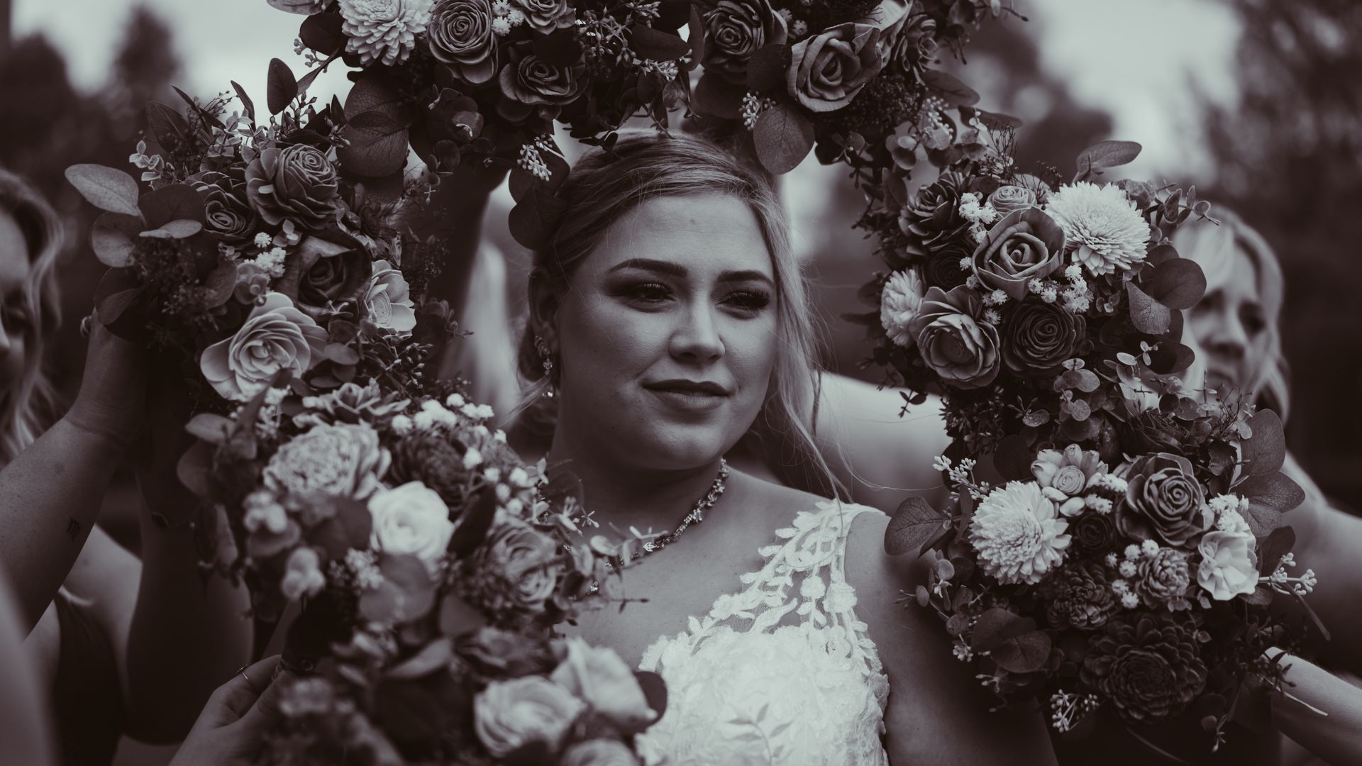 a black and white photo of a bride and her bridesmaids holding bouquets of flowers .