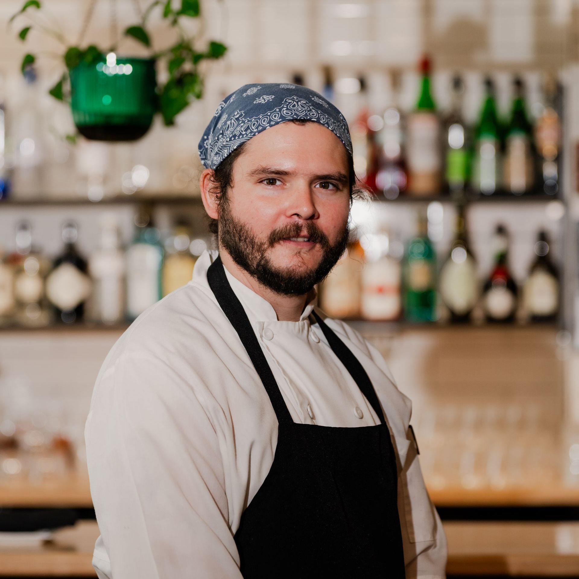 A woman in a blue scrub top is smiling for the camera for a headshot