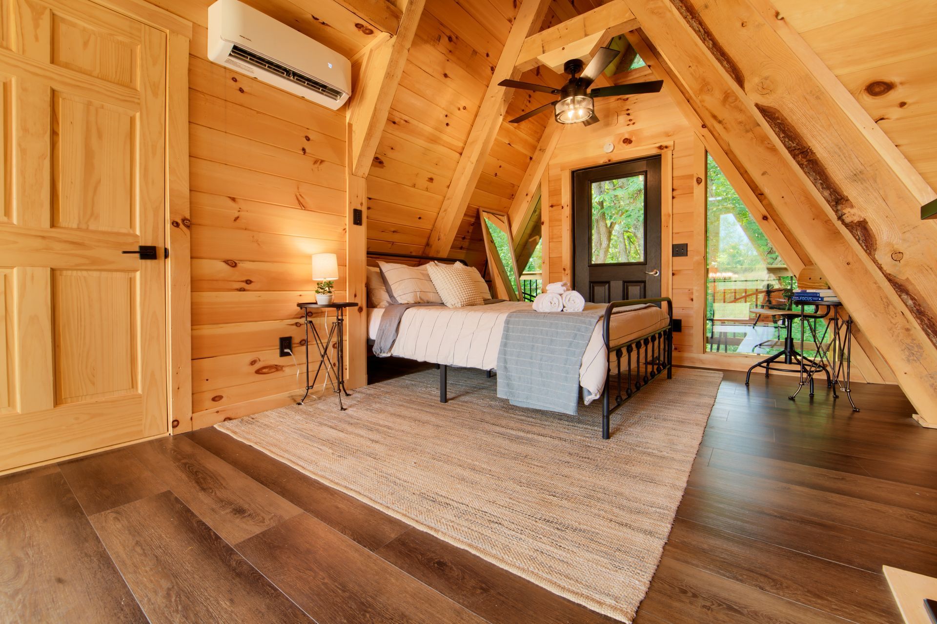 A bedroom in a wooden cabin with a bed and a ceiling fan.