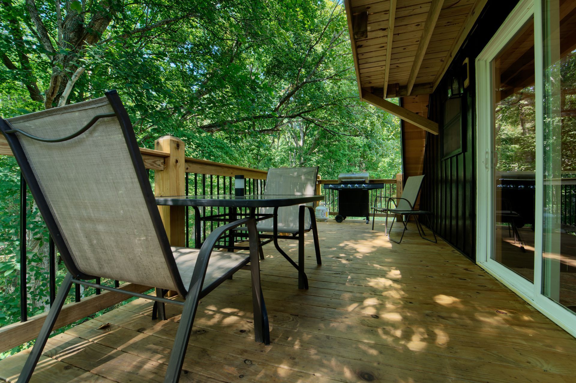 A wooden deck with chairs and a table on it