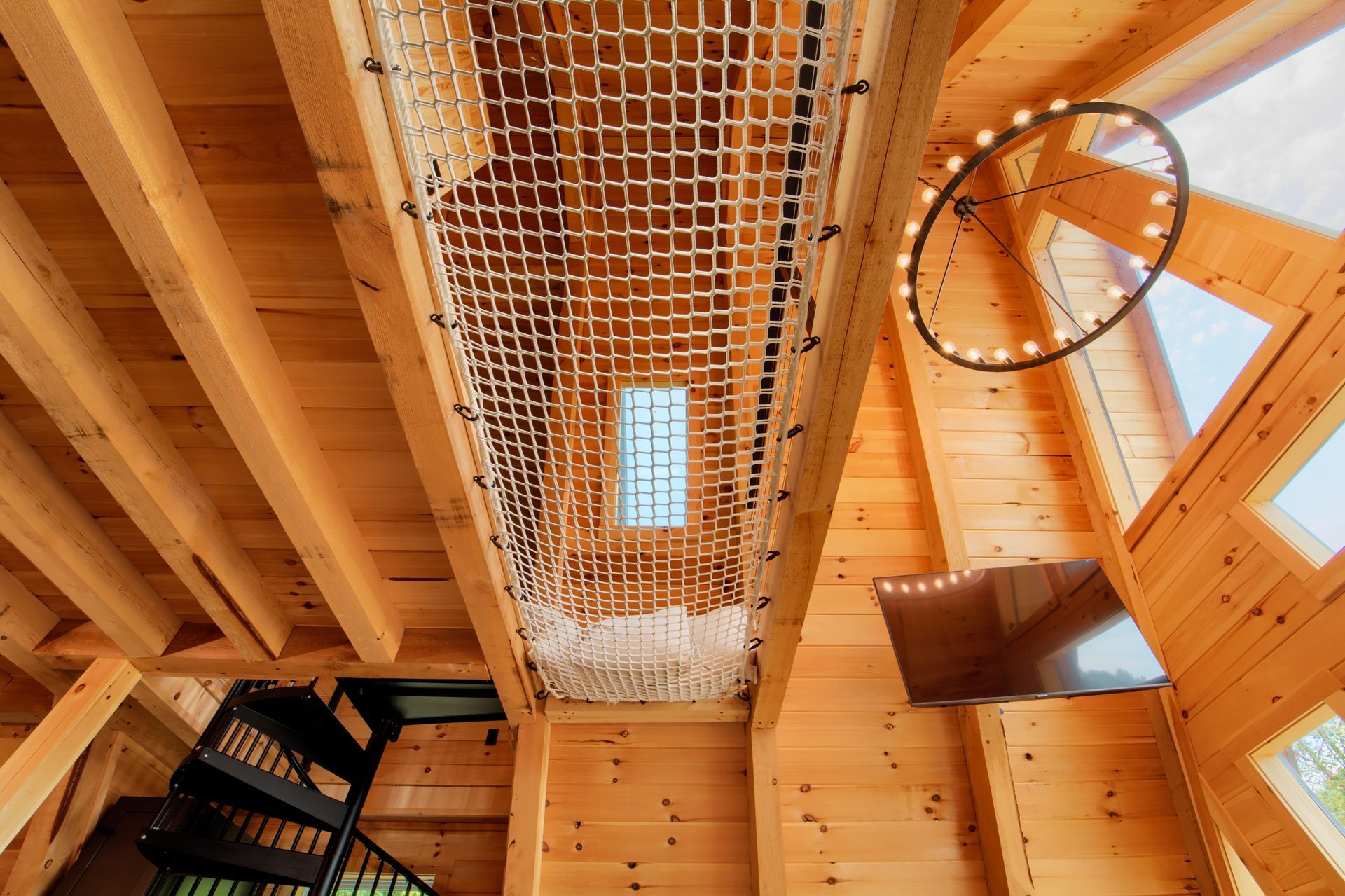 A wooden house with a staircase and a net hanging from the ceiling.