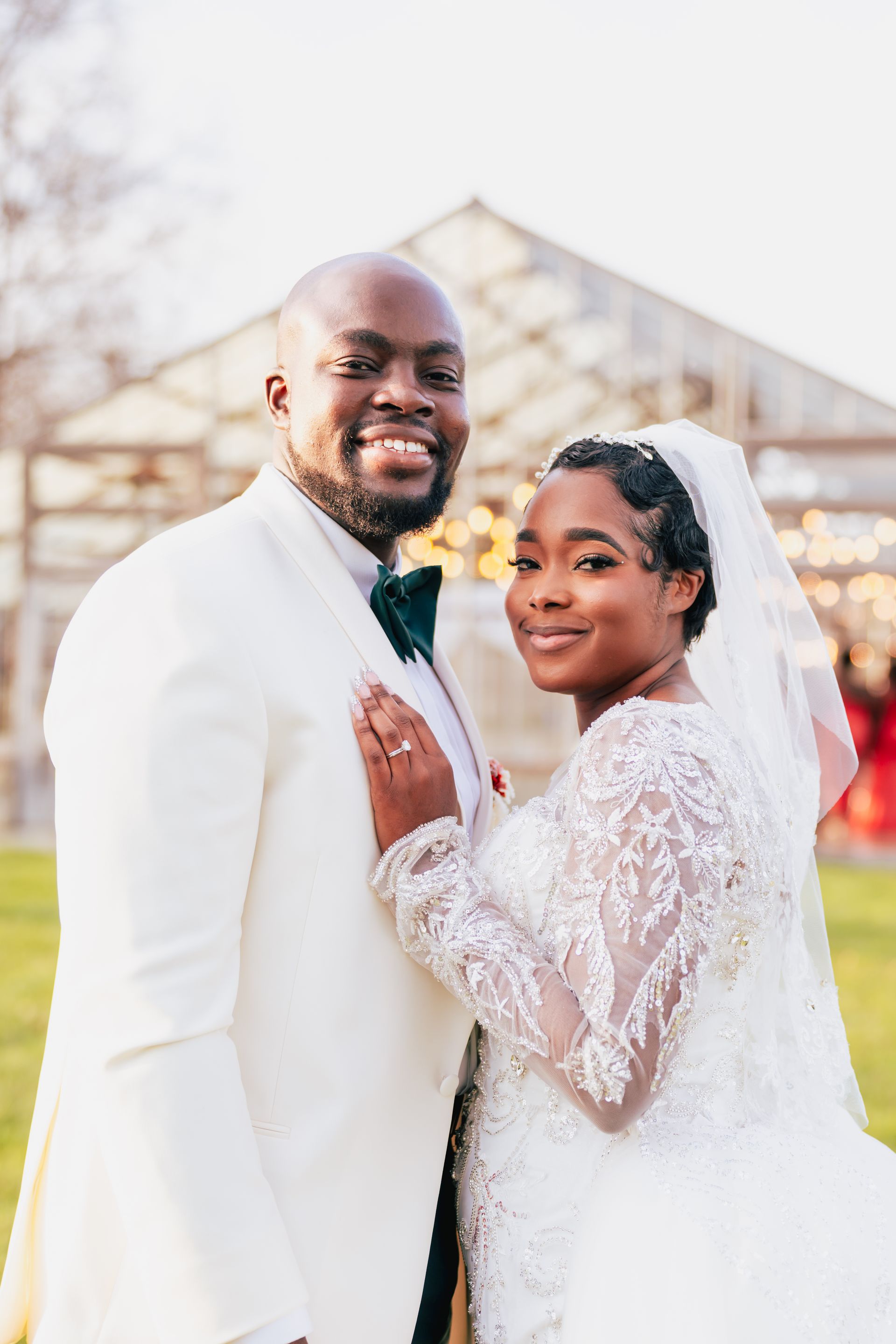 a bride and groom are walking down a path holding hands .