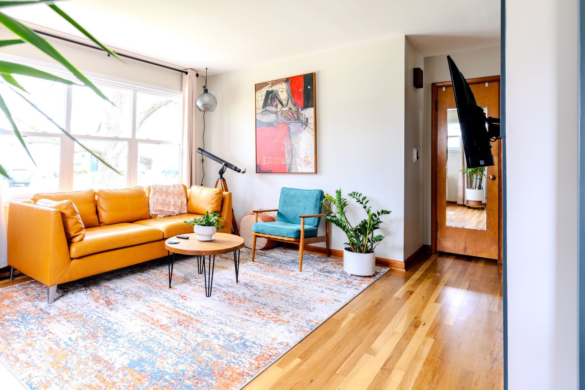 A living room with a yellow couch and a blue chair.