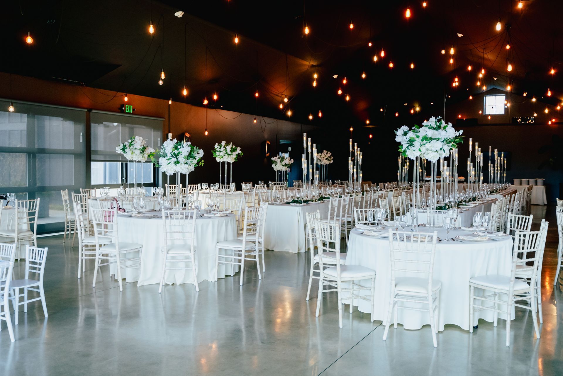 A large room with tables and chairs set up for a wedding reception.