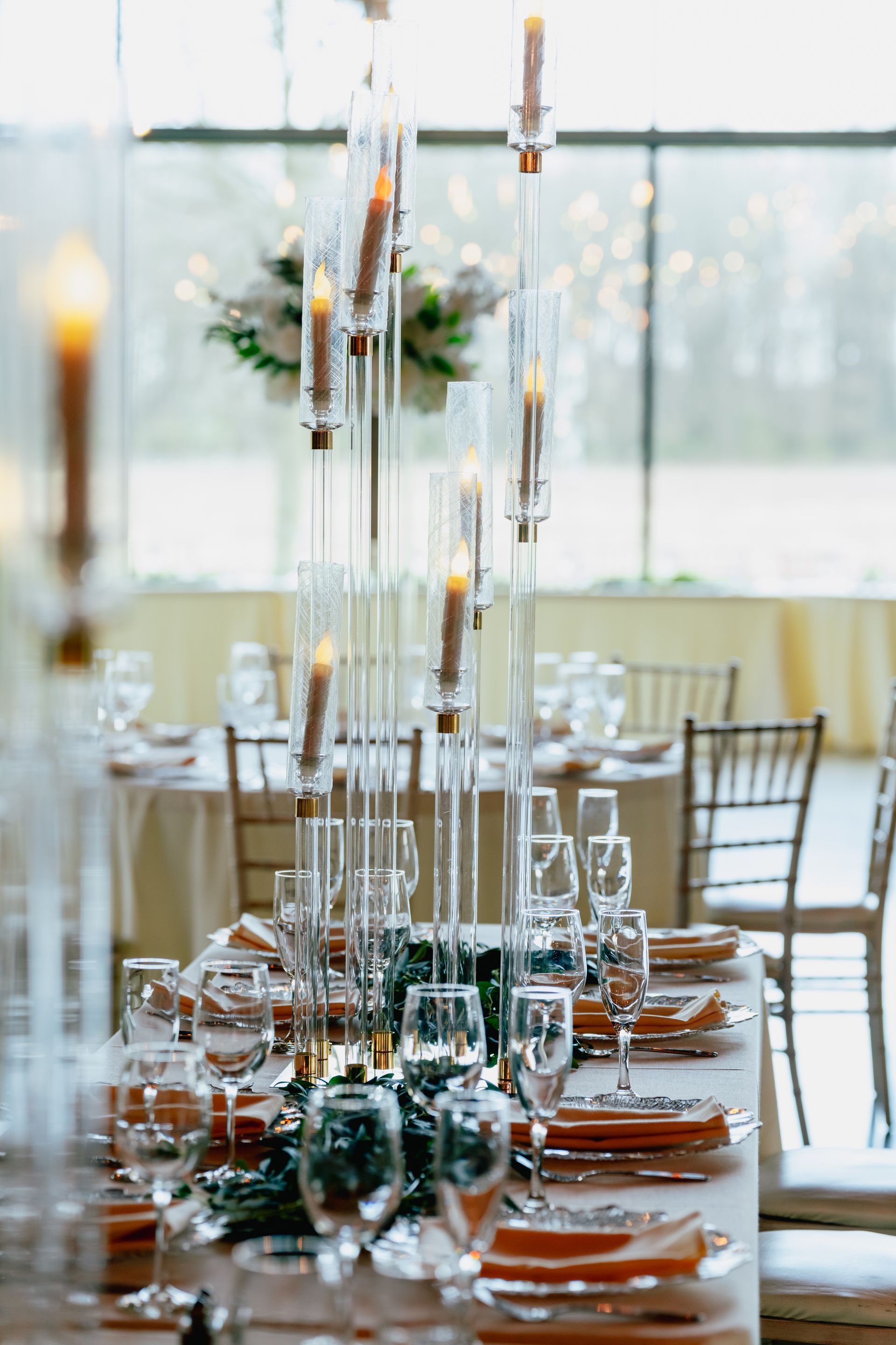 A long table set for a wedding reception with candles and plates.