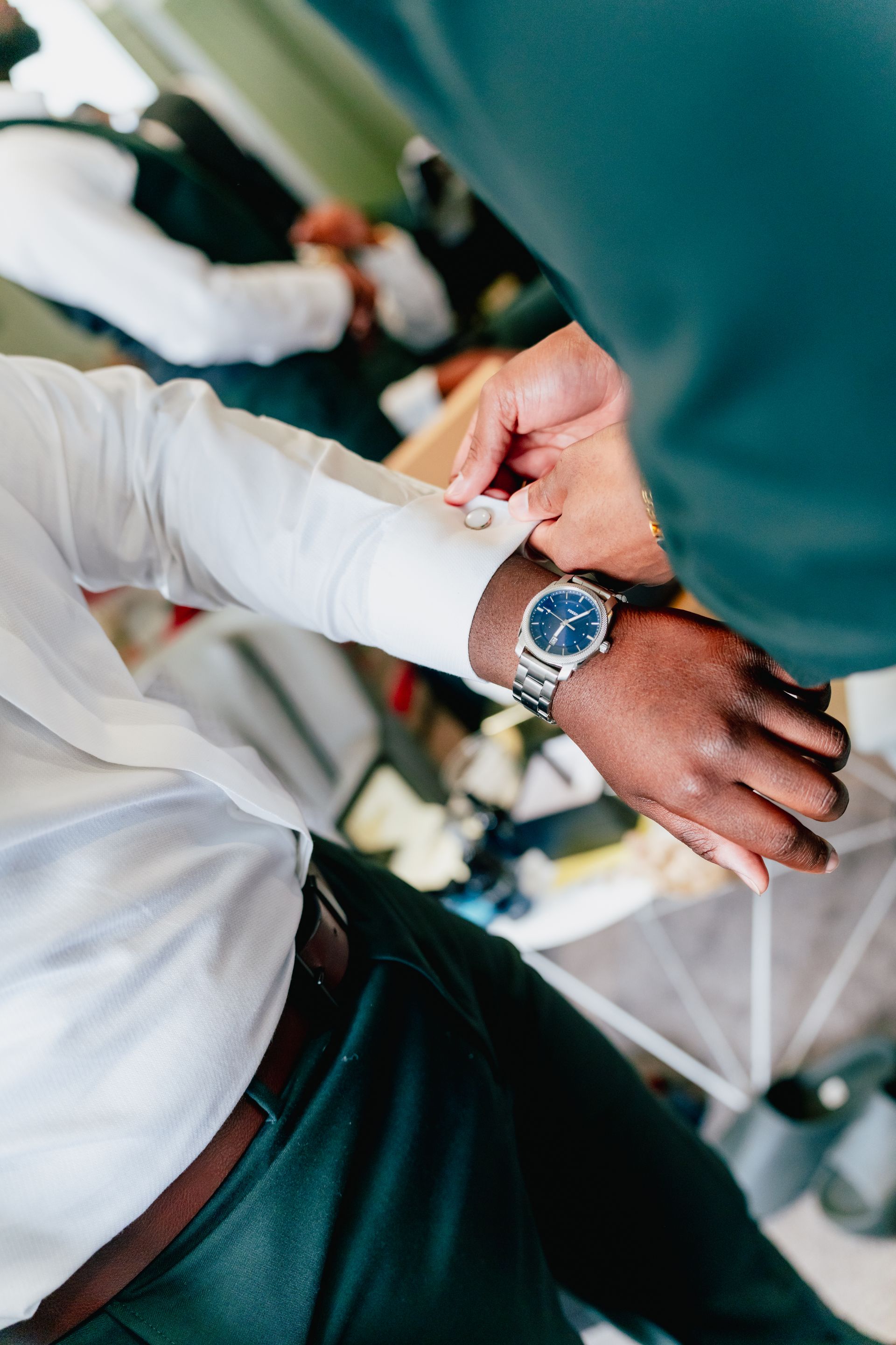 A groom wearing a watch is getting ready for a wedding.
