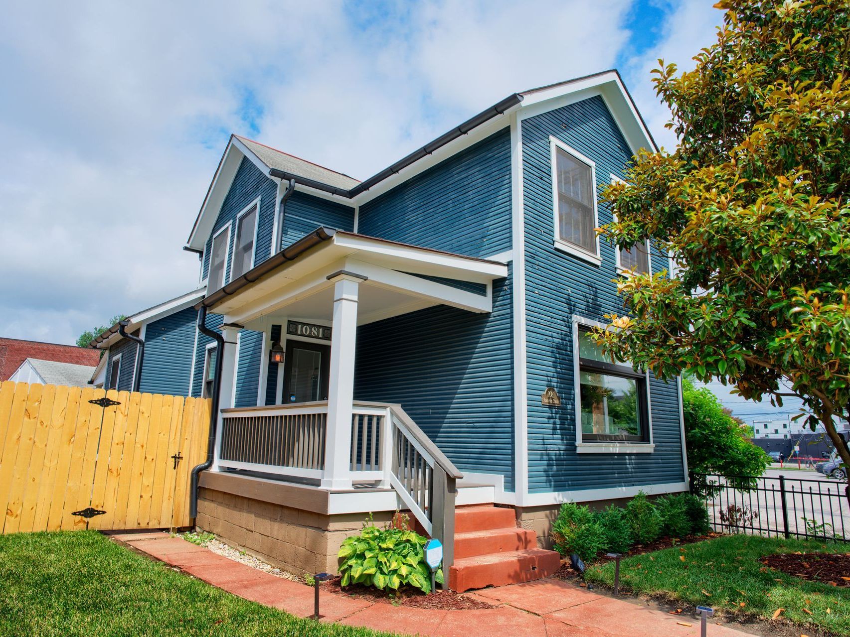 A blue house with a wooden fence in front of it