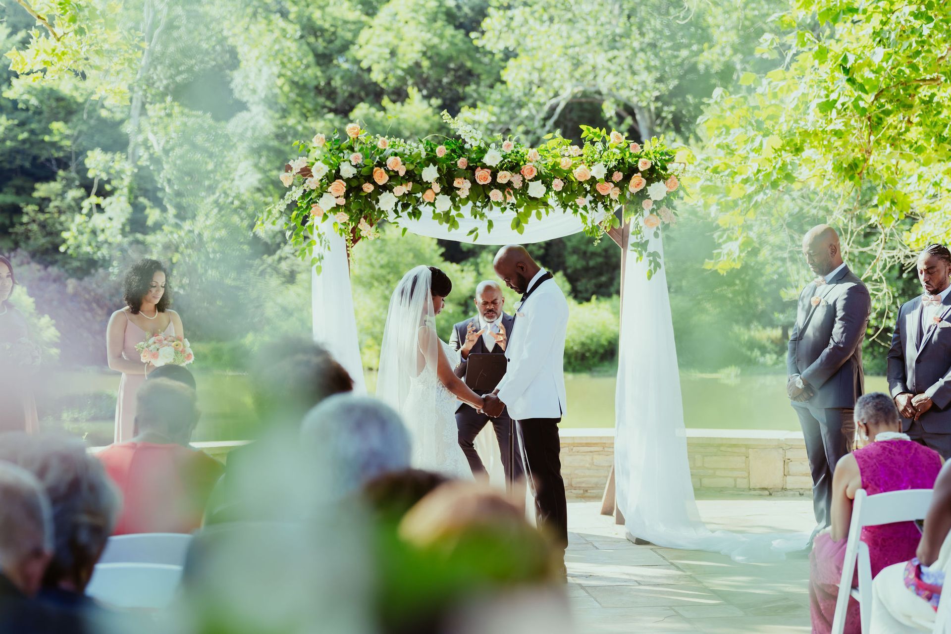 A bride and groom are holding hands during their wedding ceremony.