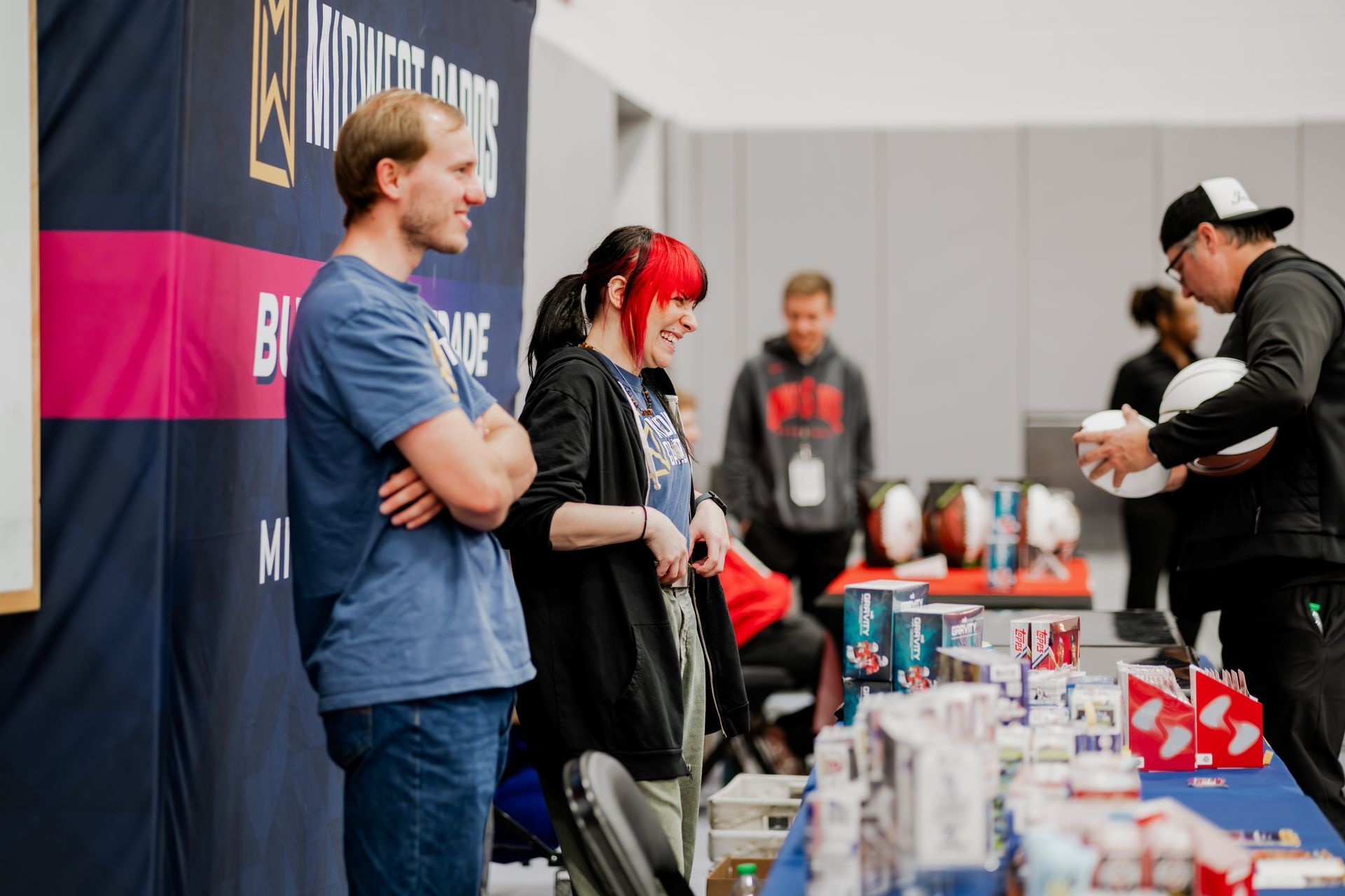 Merchandise on the table. Indoor setting with a banner.Midwest Card | Event Photography