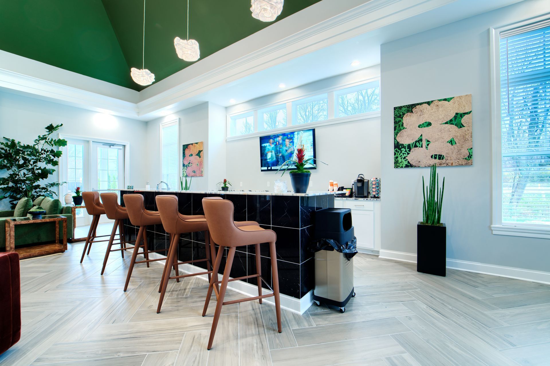 A large room with a bar and stools in it.