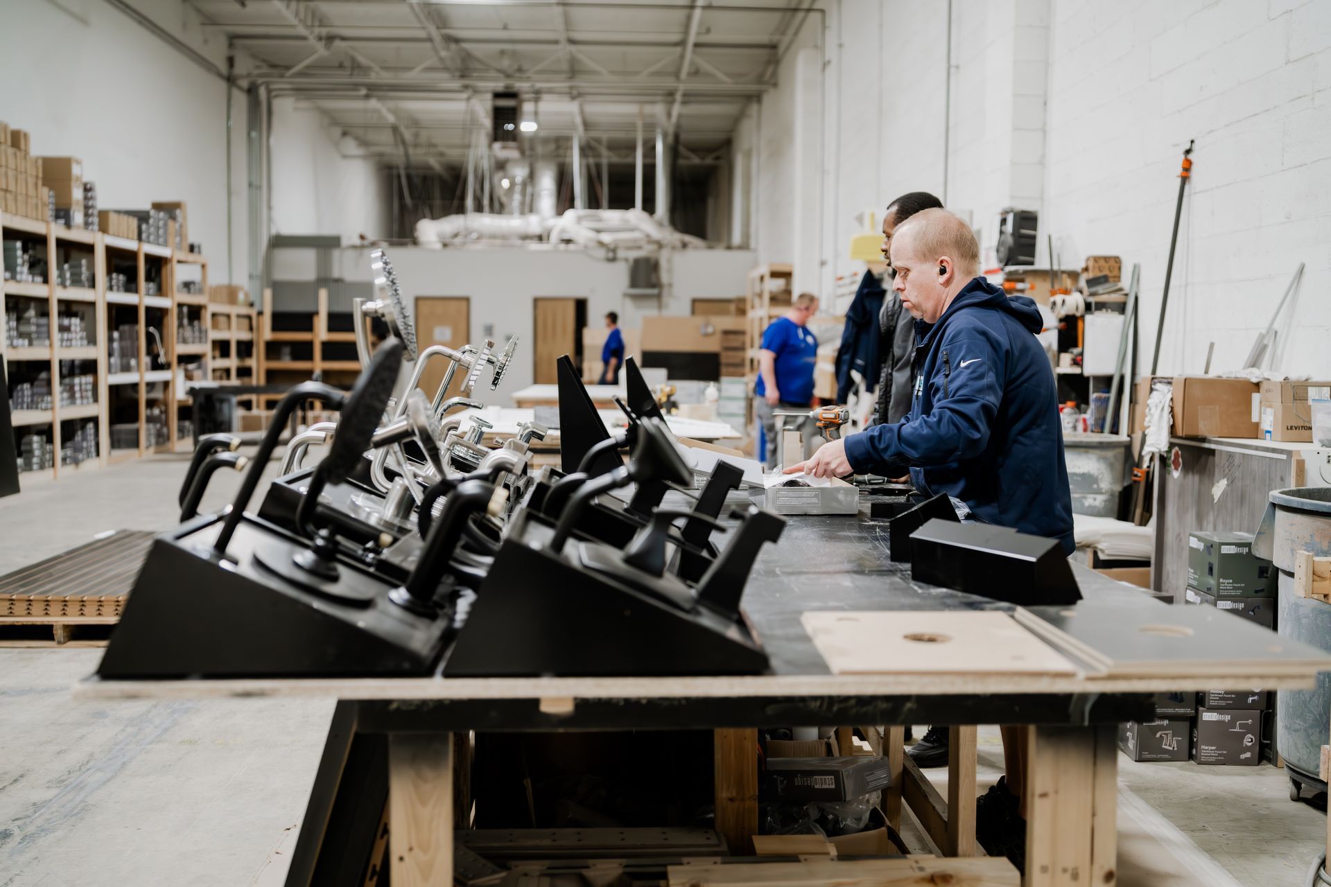 Workshop interior, workers assembling equipment. 