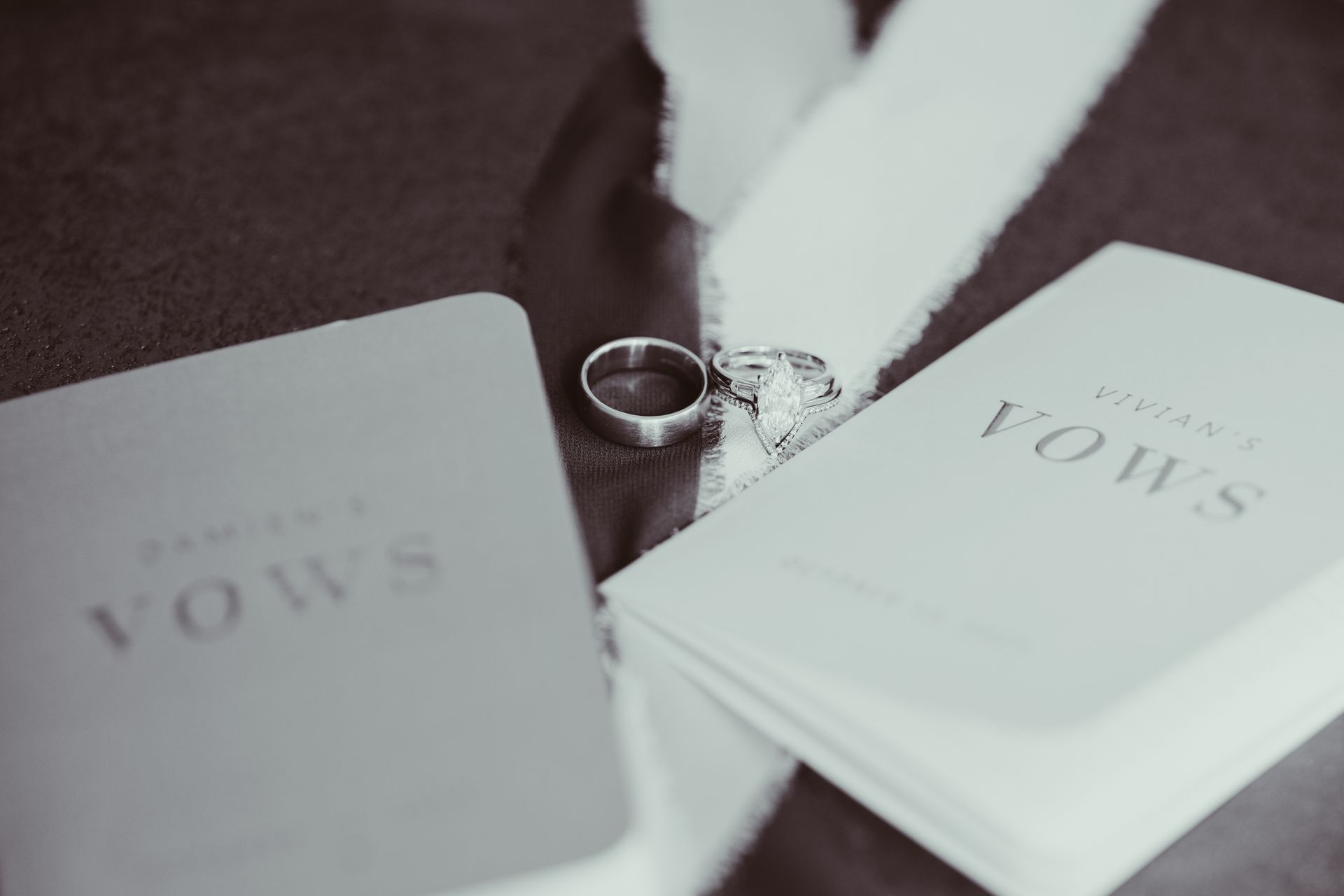 Wedding rings rest on fabric beside 