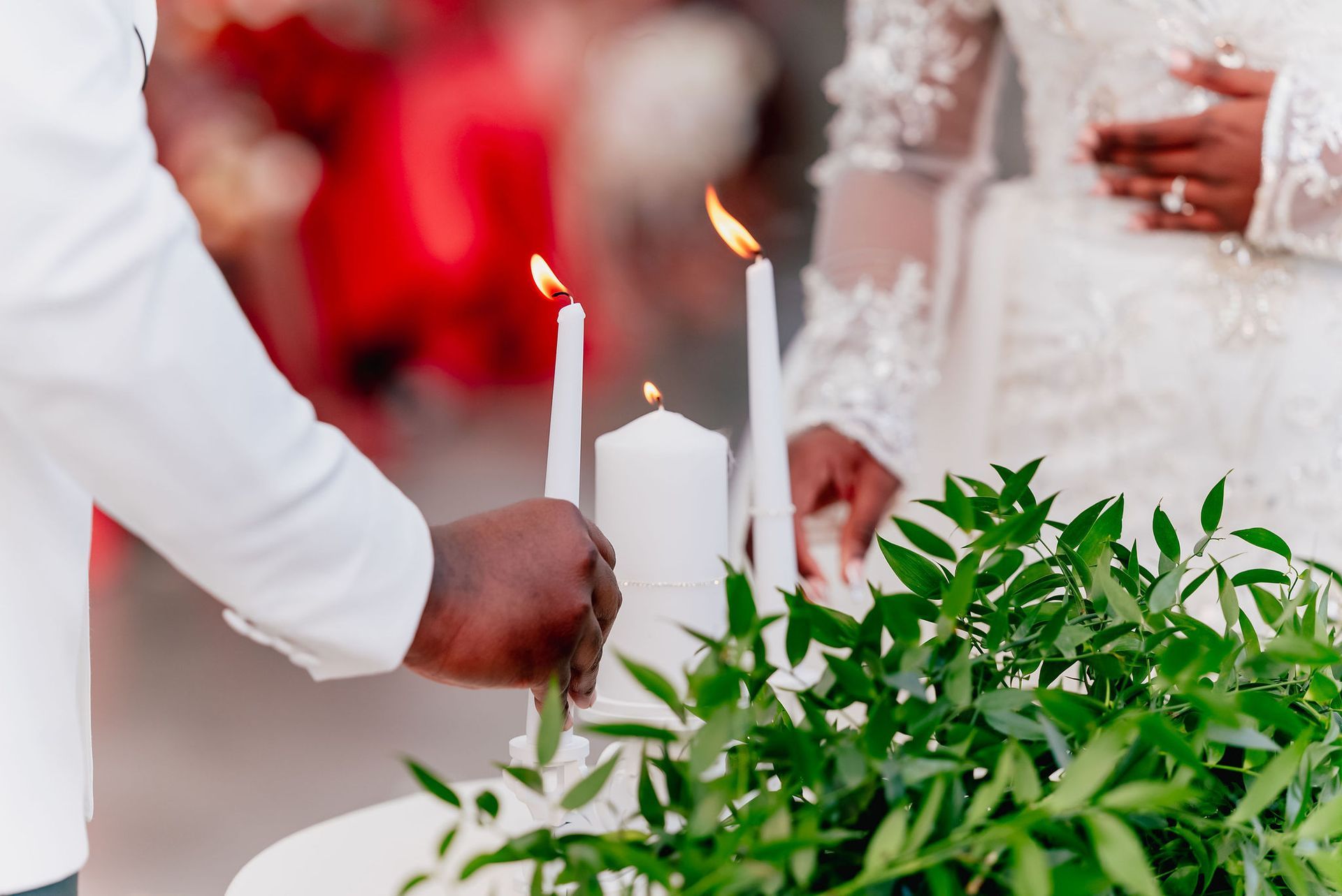 A bride and groom are lighting candles at their wedding ceremony.