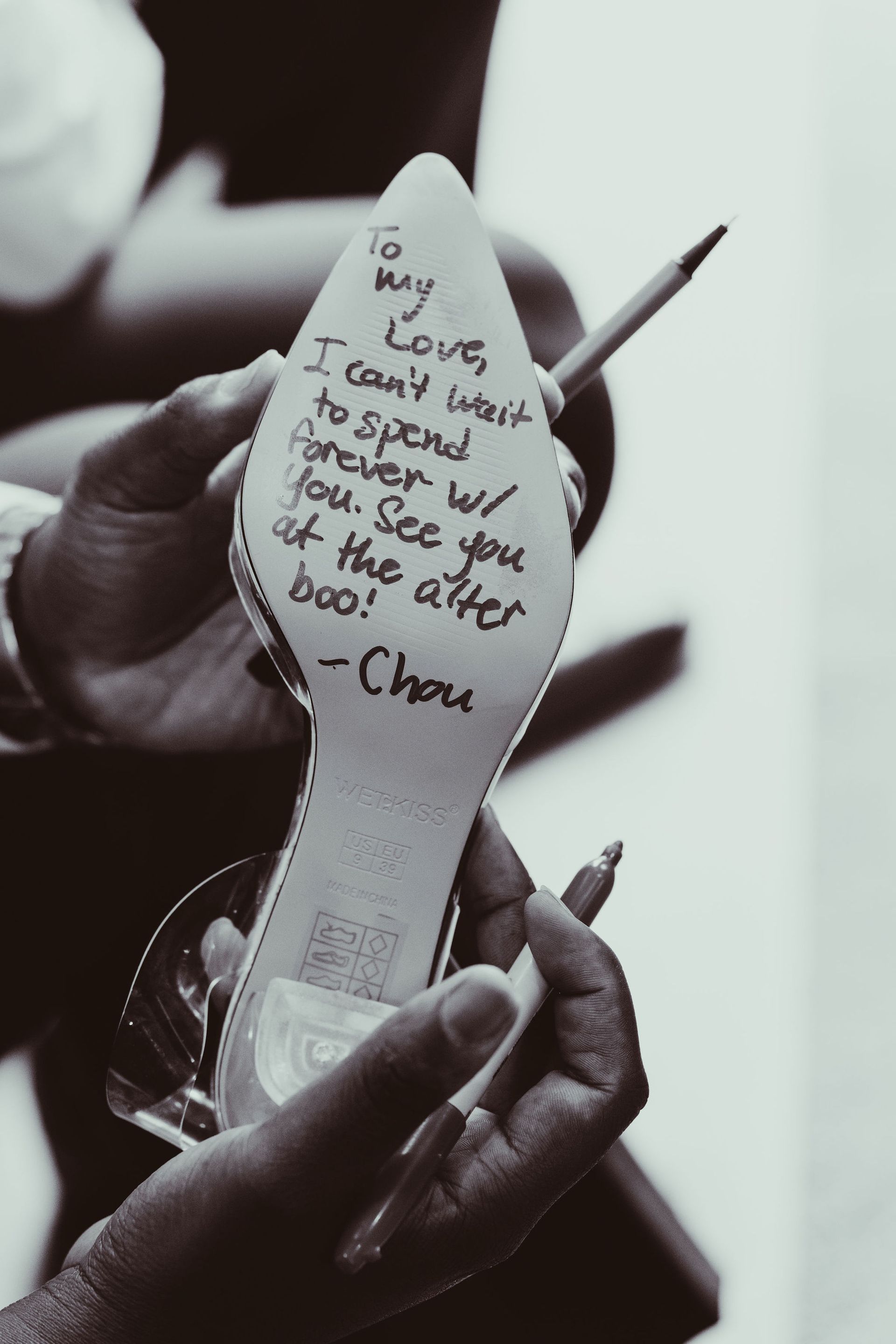 A person is writing on a shoe with a pencil