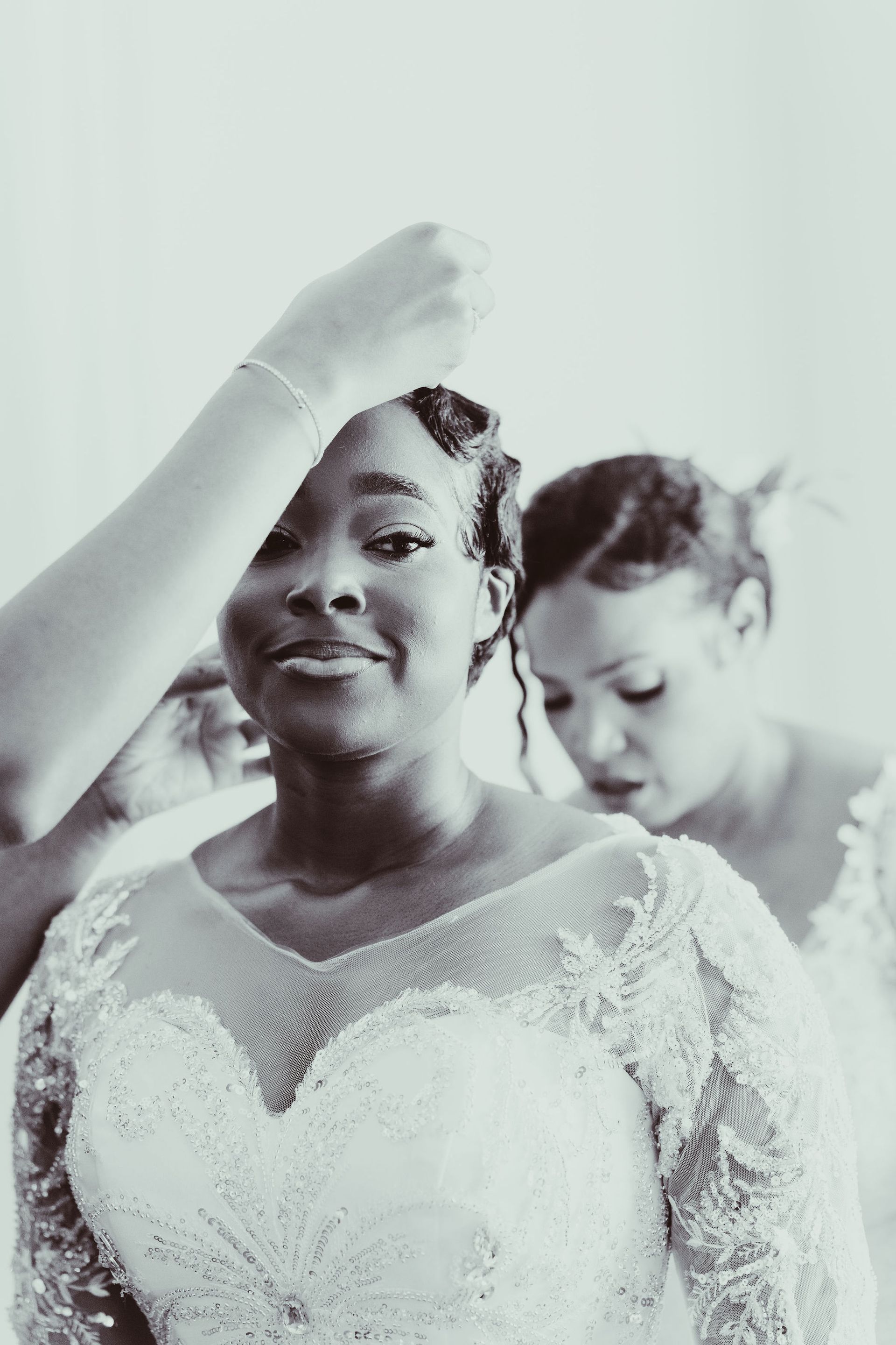 A black and white photo of a bride getting ready for her wedding.