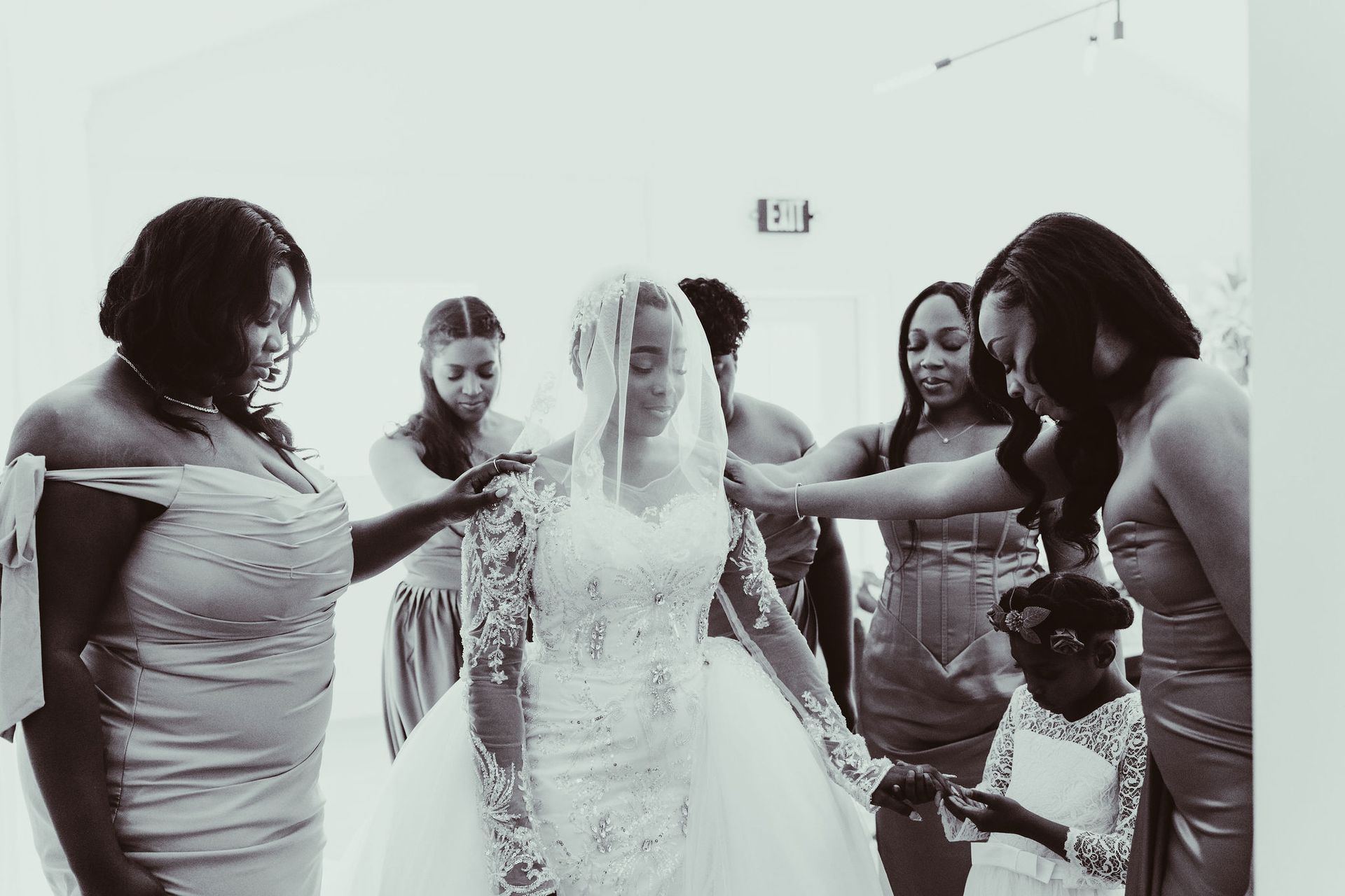 A group of women are standing around a bride in a wedding dress.