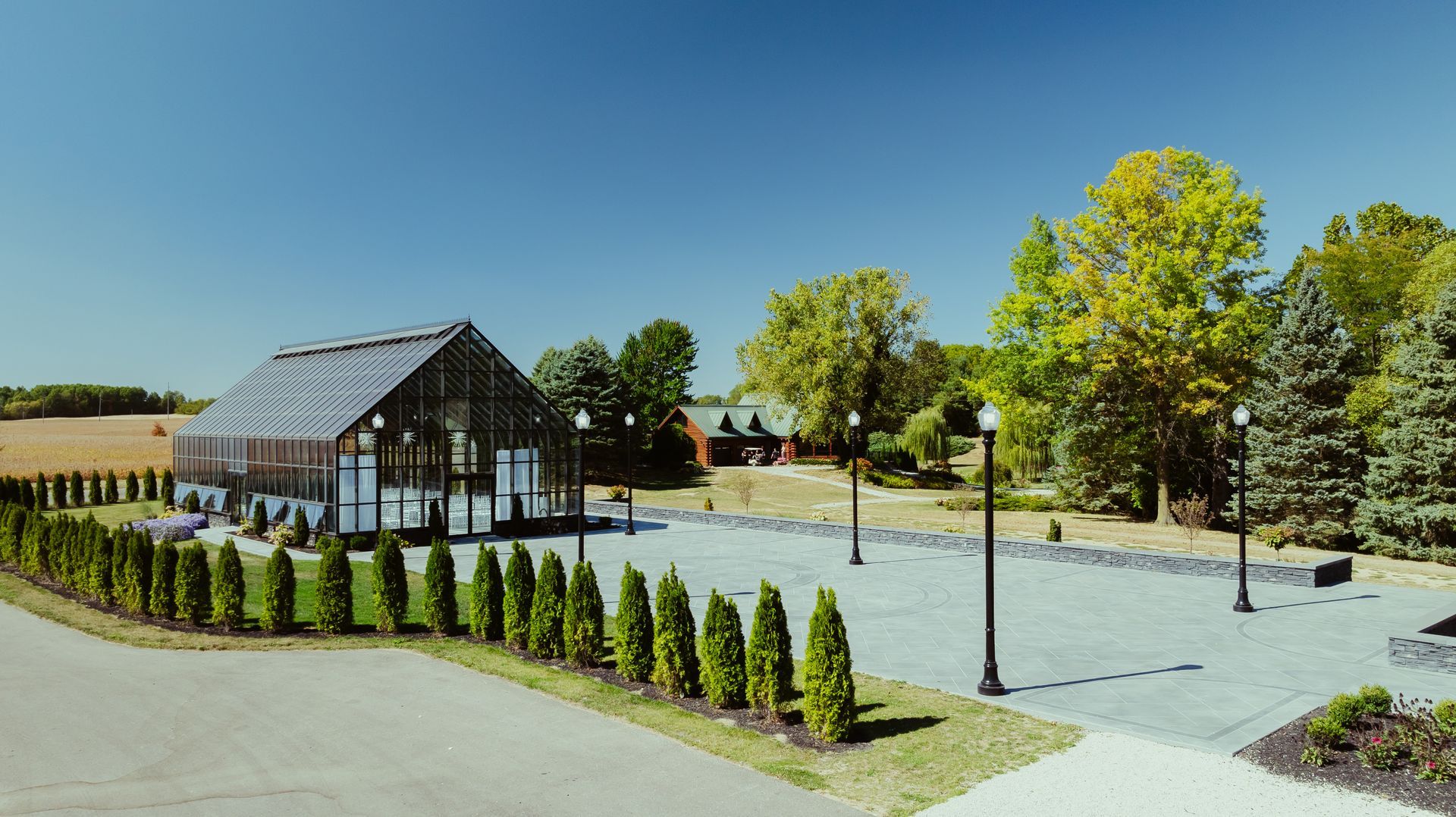 There is a greenhouse in the middle of a park surrounded by trees.