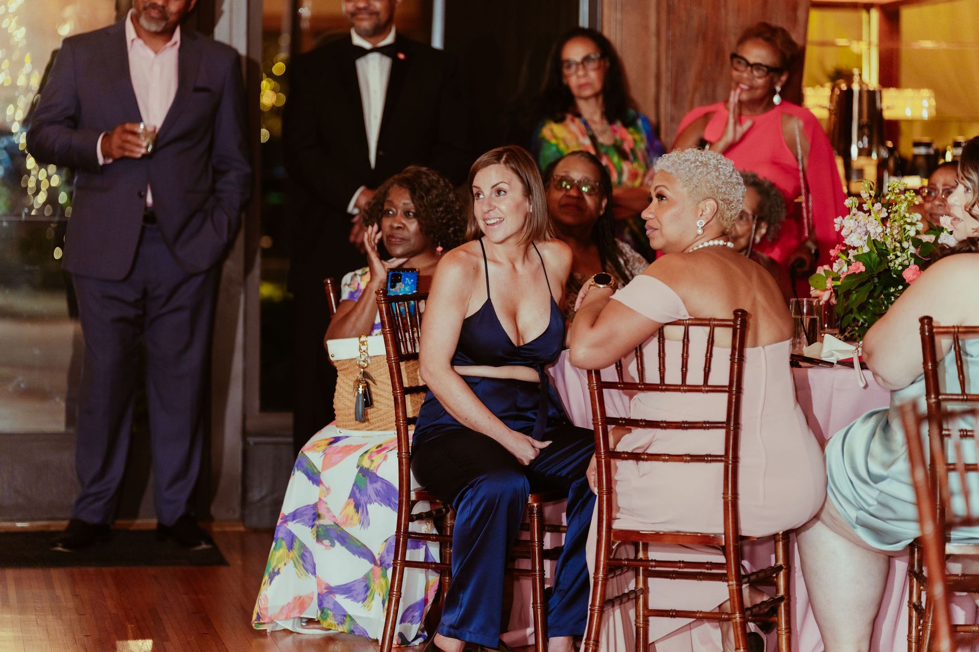 A group of people are sitting at tables at a wedding reception.