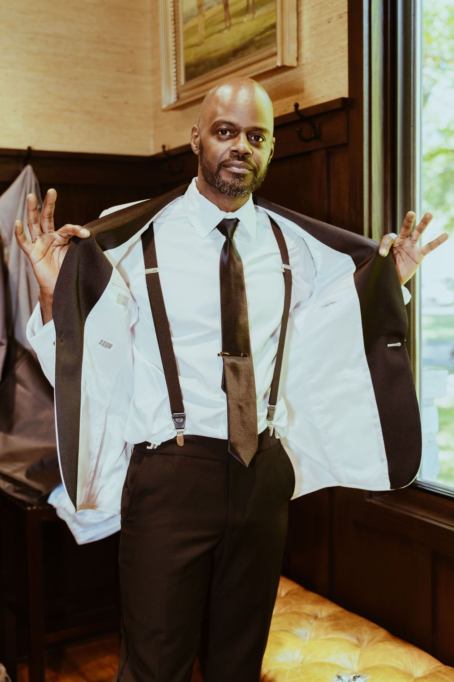 A man in a suit and tie is holding his jacket over his shoulder.