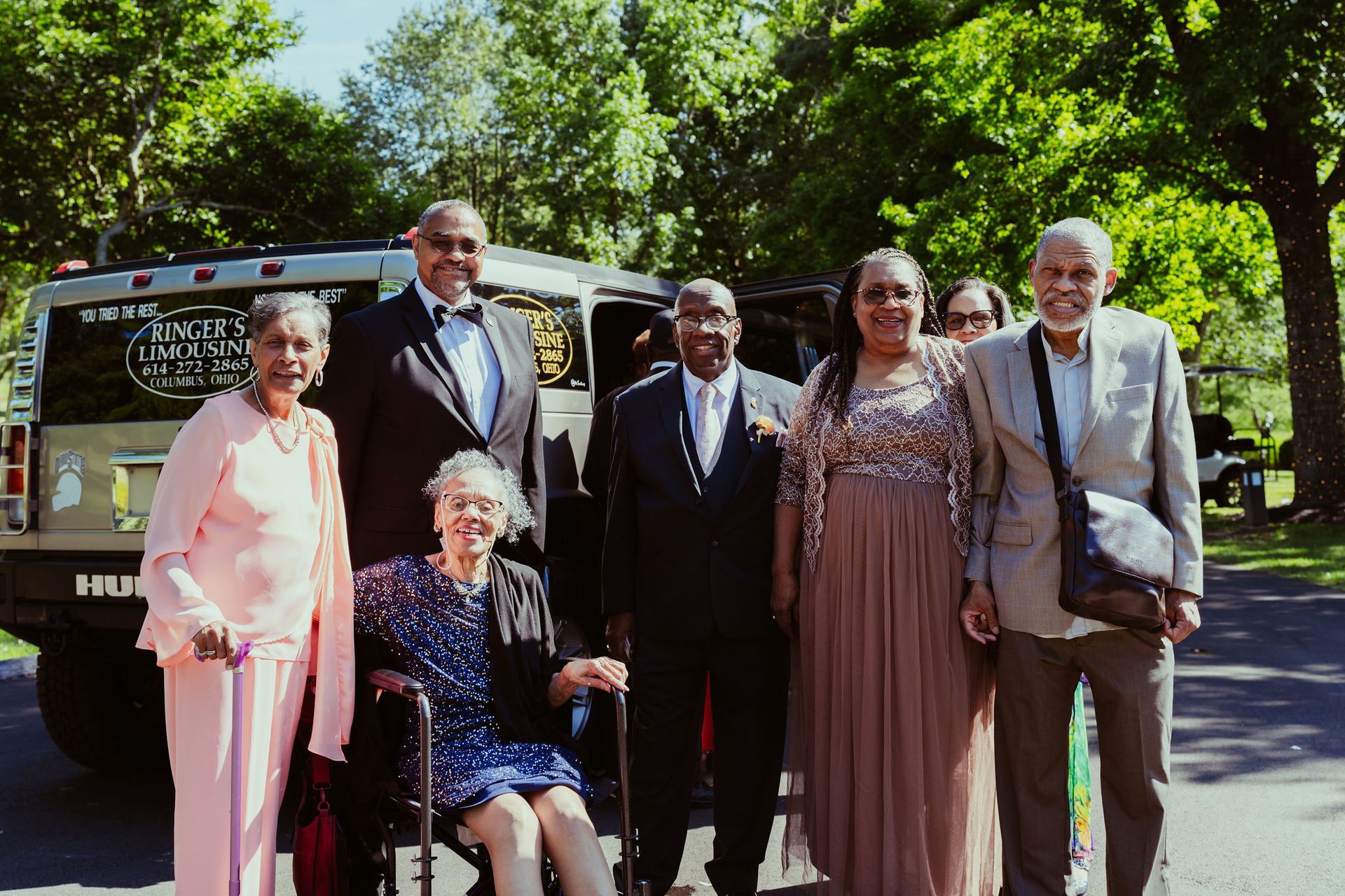 A group of people posing for a picture in front of a hummer